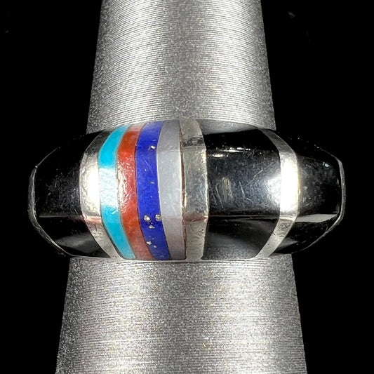 A sterling silver ring inlaid with onyx, turquoise, coral, lapis lazuli, and mother of pearl stones.