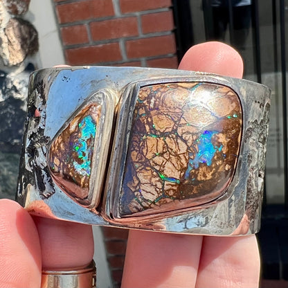 A men's sterling silver and copper infused cuff bracelet set with two boulder opal stones from Koroit, Australia.