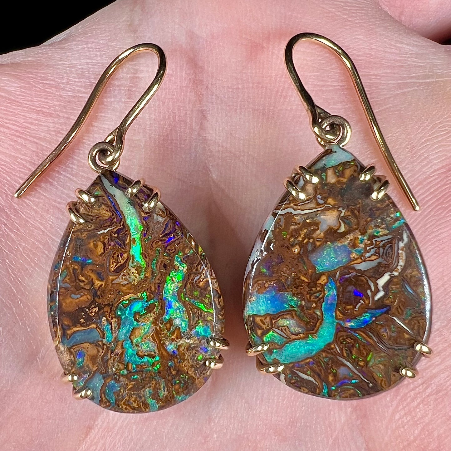 A pair of ladies' yellow gold dangle earrings set with pear shaped natural boulder opal stones from Koroit, Australia.