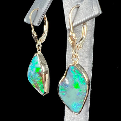 A pair of yellow gold dangle earrings set with Australian boulder opal stones.