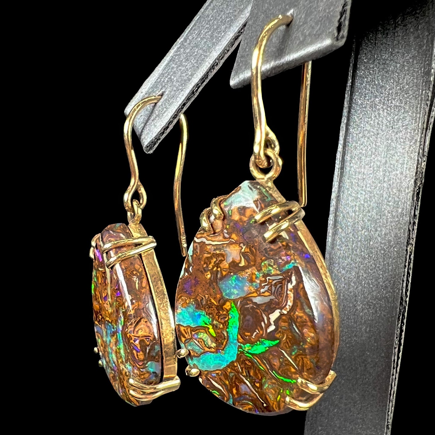 A pair of ladies' yellow gold dangle earrings set with pear shaped natural boulder opal stones from Koroit, Australia.