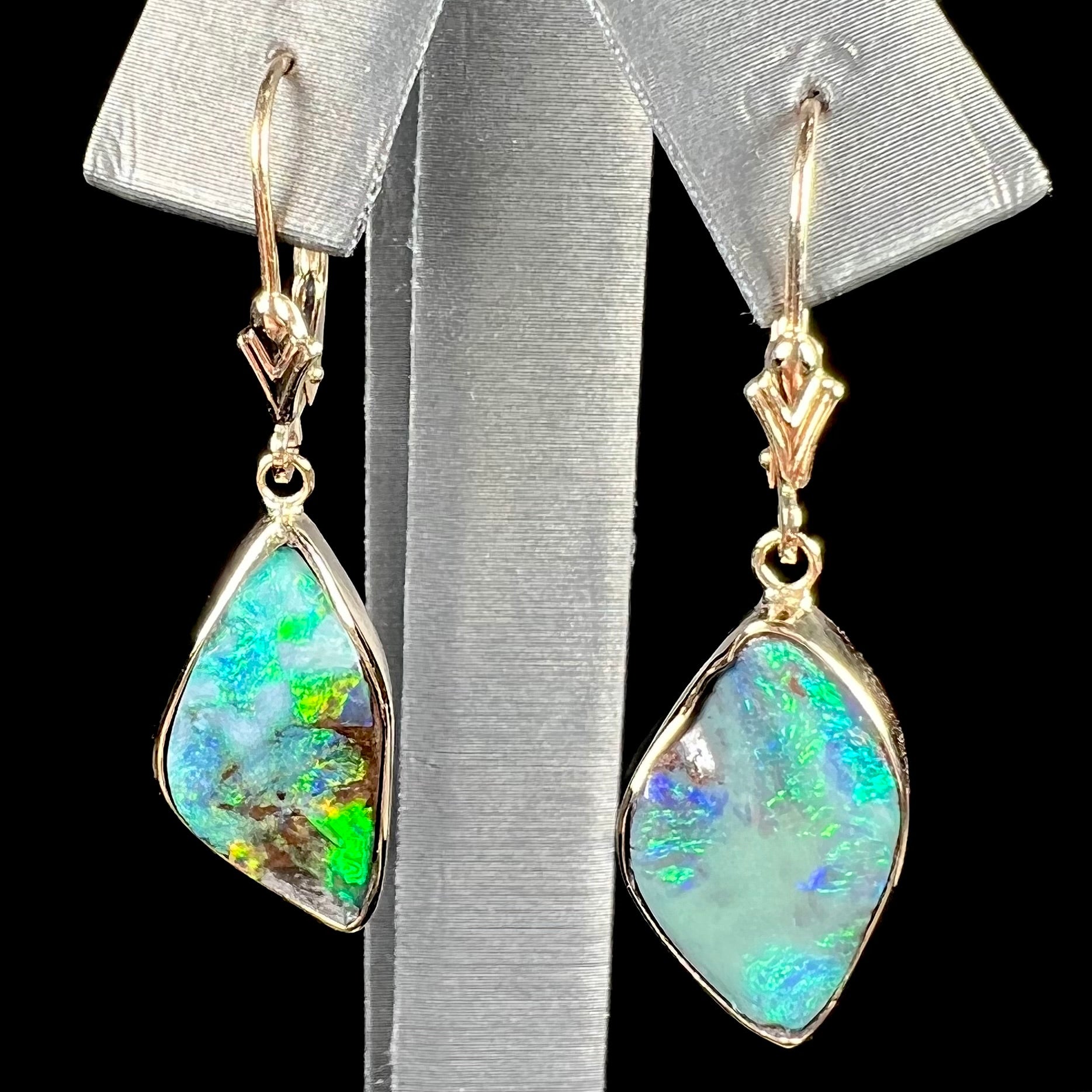A pair of yellow gold dangle earrings set with Australian boulder opal stones.