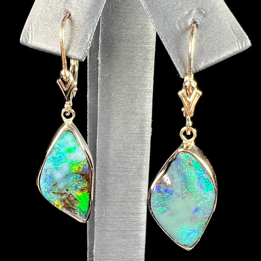 A pair of yellow gold dangle earrings set with Australian boulder opal stones.