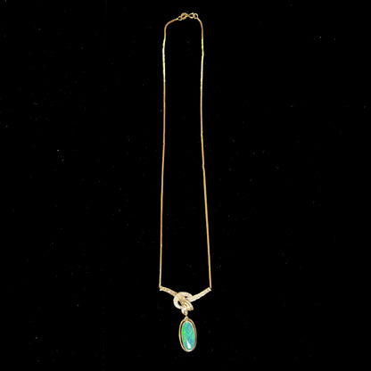 A gold black opal and diamond necklace.  There are round, princess cut, and baguette cut diamonds.