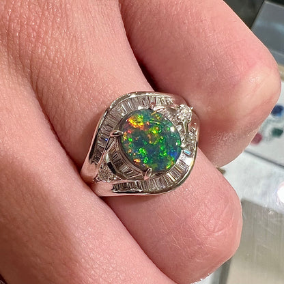 A platinum Lightning Ridge black opal ring set with baguette cut diamonds.  The opal is an oval cabochon cut.