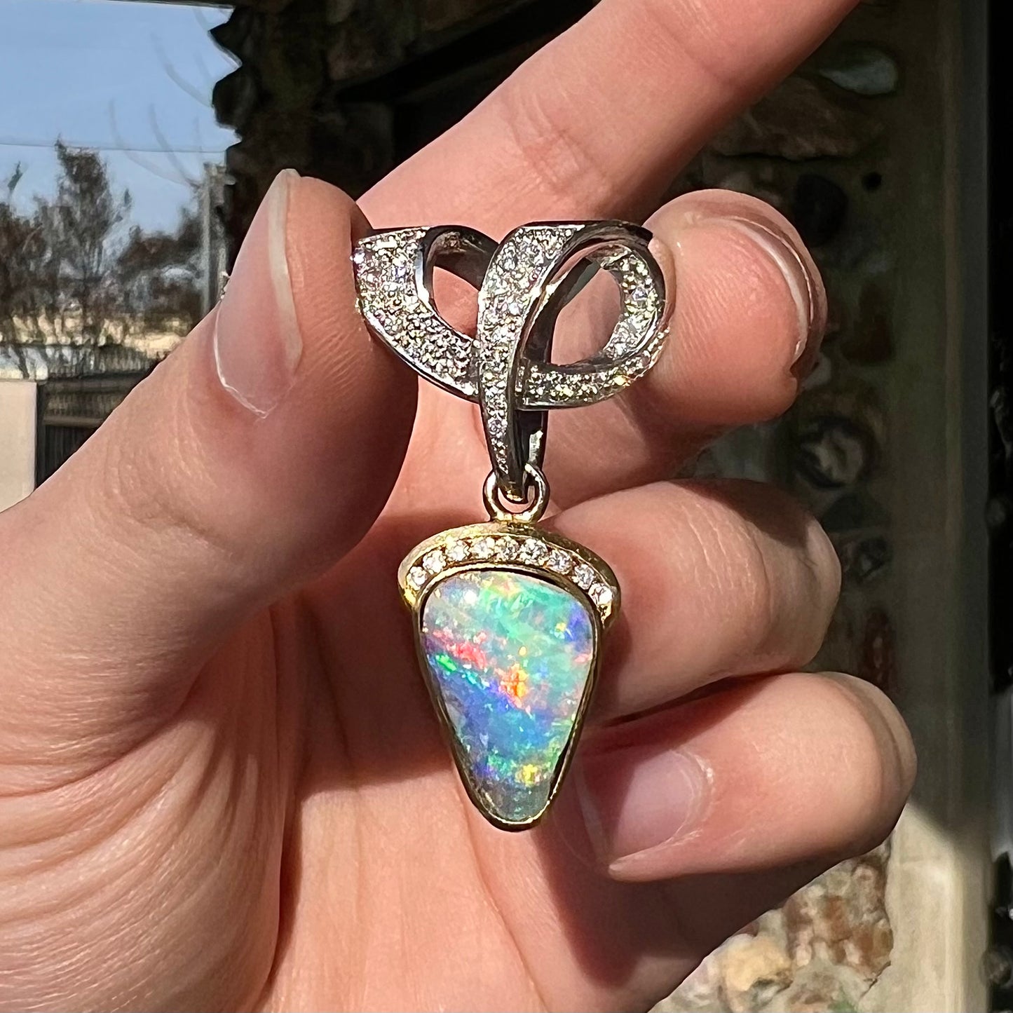 A ladies' 18kt two tone white and yellow gold Australian black boulder opal and diamond pendant.