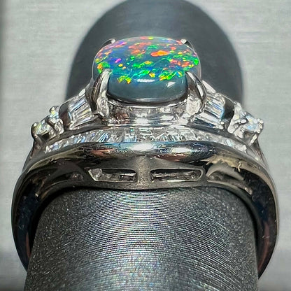 A platinum Lightning Ridge black opal ring set with baguette cut diamonds.  The opal is an oval cabochon cut.