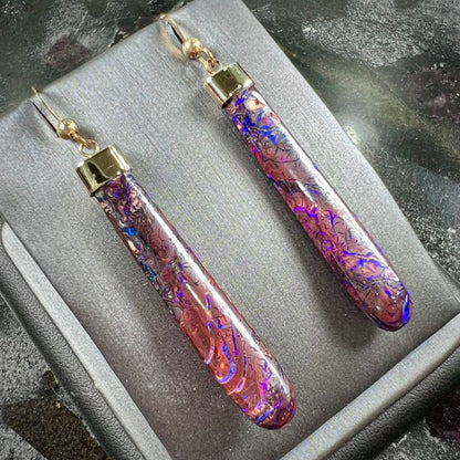 A pair of yellow gold cap Koroit boulder opal dangle earrings.  Purple highlights are seen.