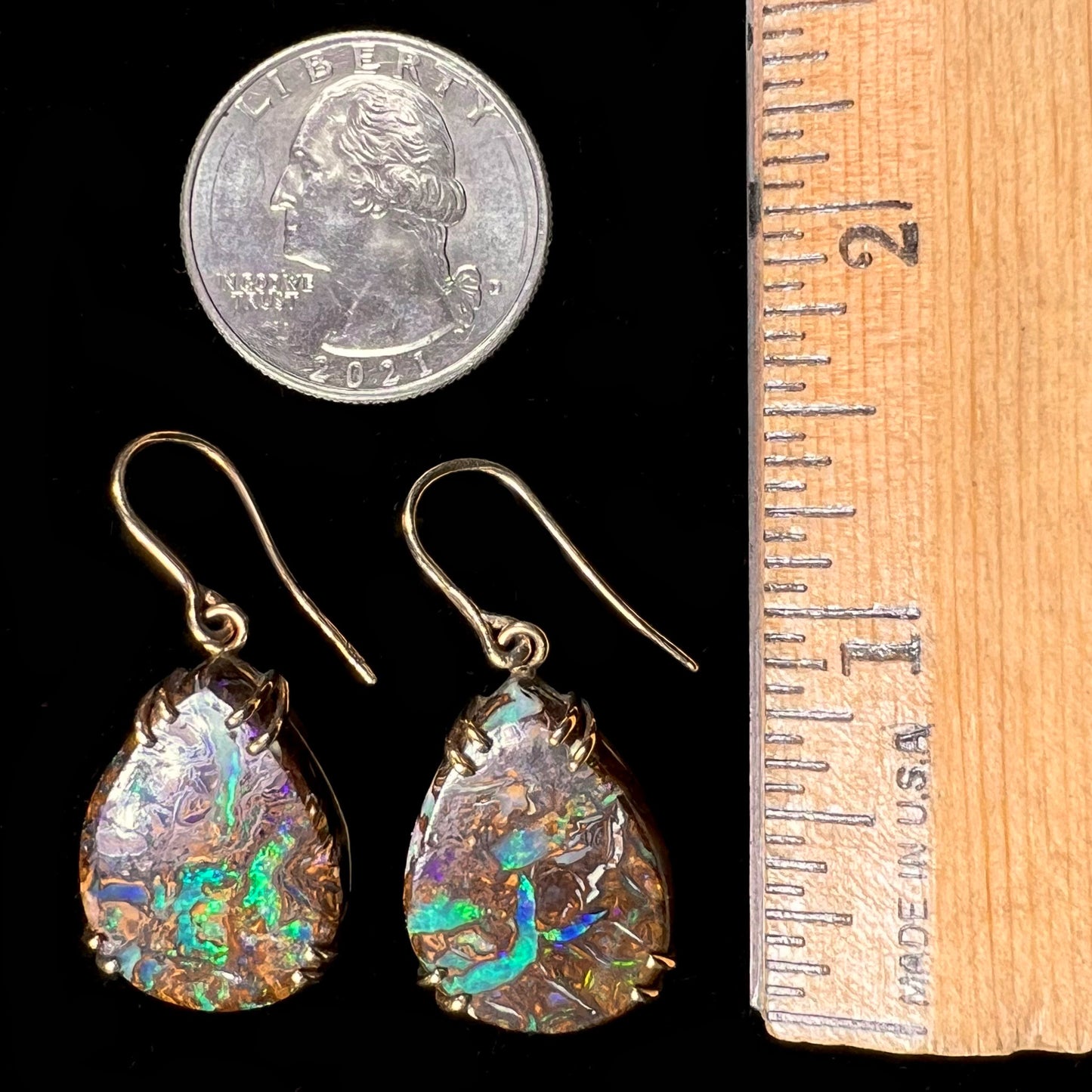 A pair of ladies' yellow gold dangle earrings set with pear shaped natural boulder opal stones from Koroit, Australia.