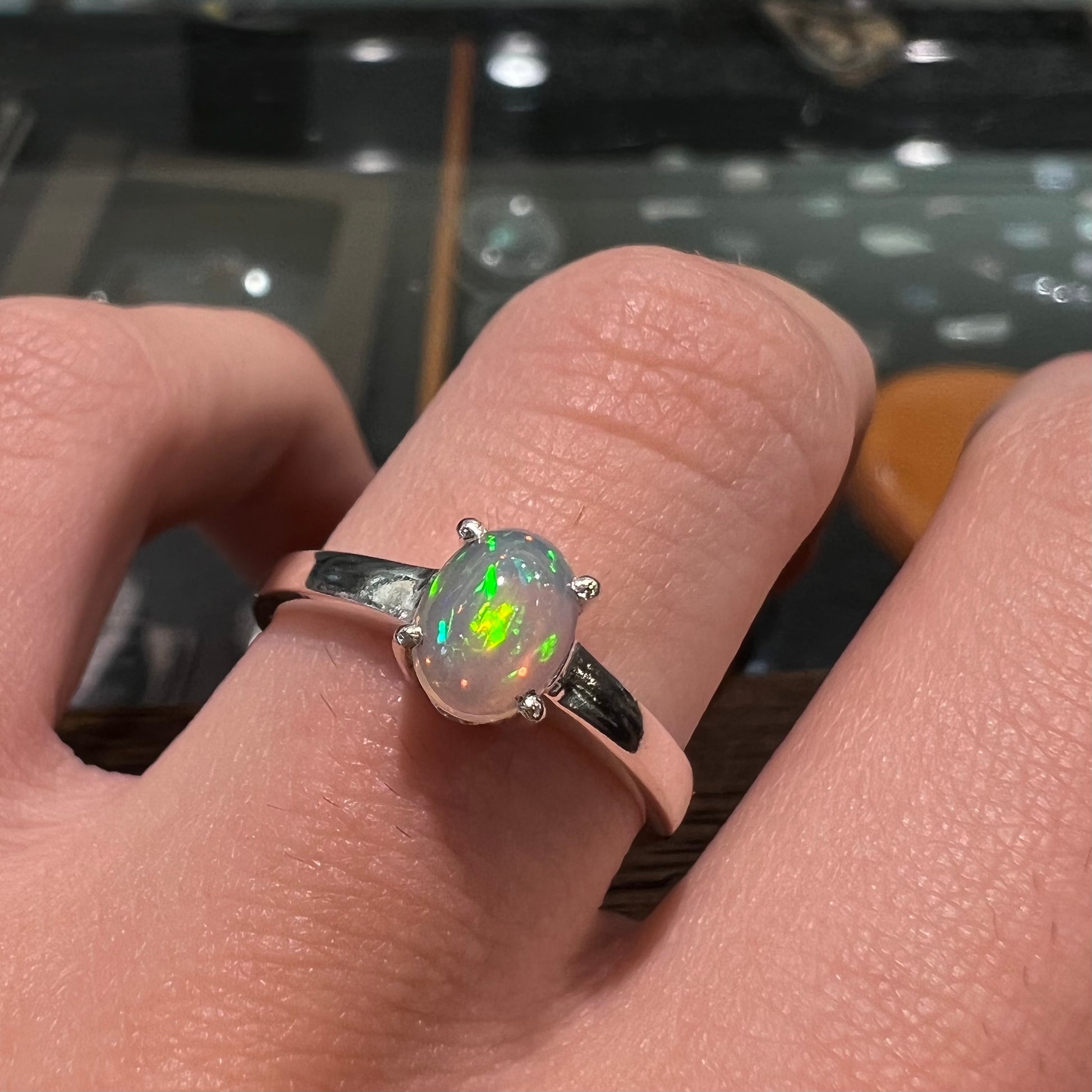 A silver, prong set, oval cabochon cut Ethiopian opal solitaire ring.