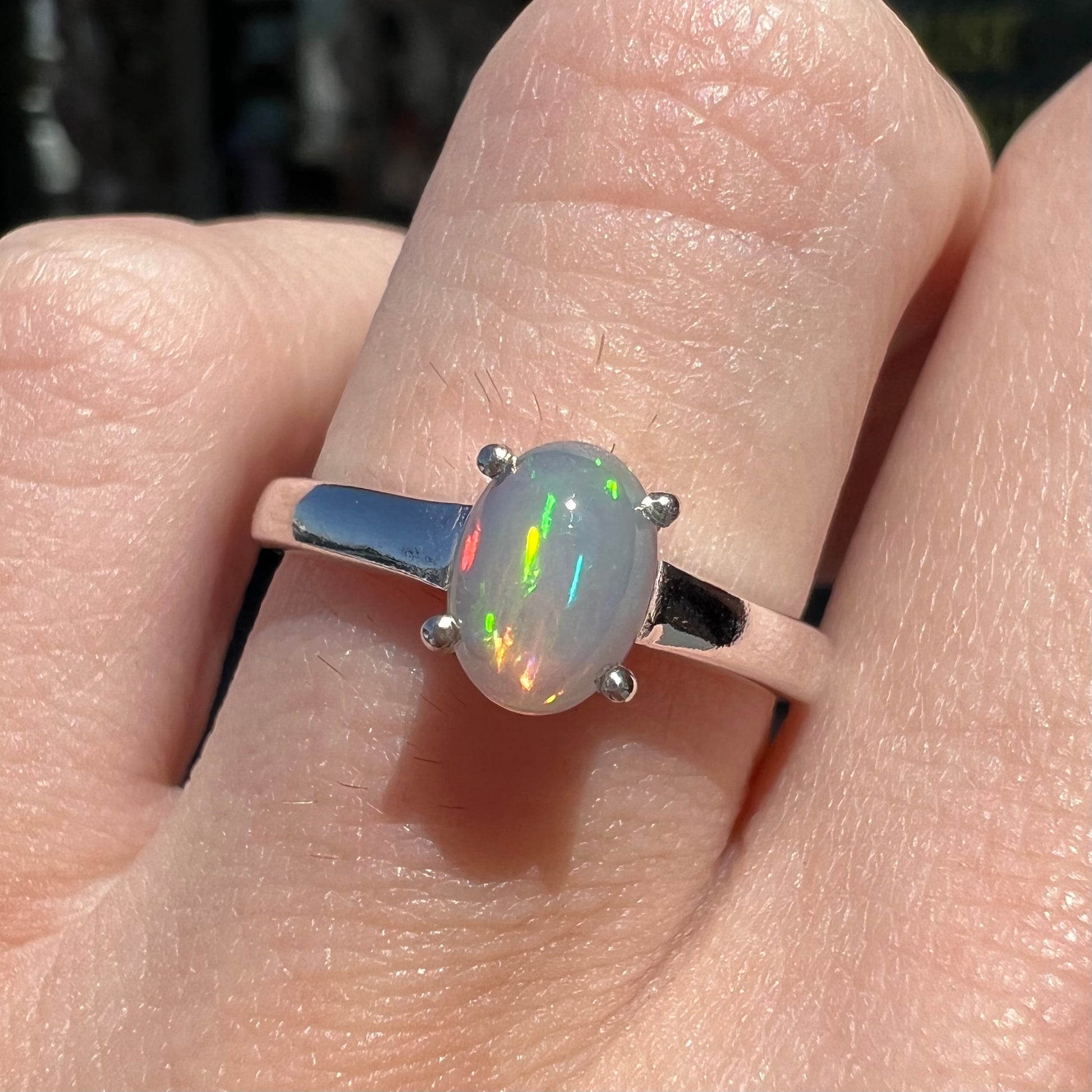 A silver, prong set, oval cabochon cut Ethiopian opal solitaire ring.