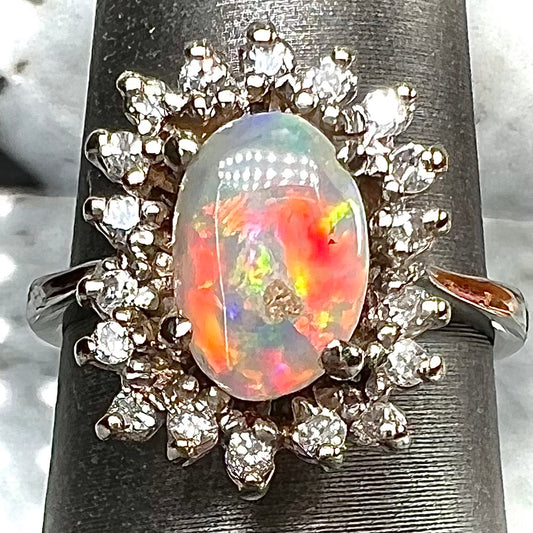 A white crystal opal ring cast in white gold with a halo of round cut diamonds.