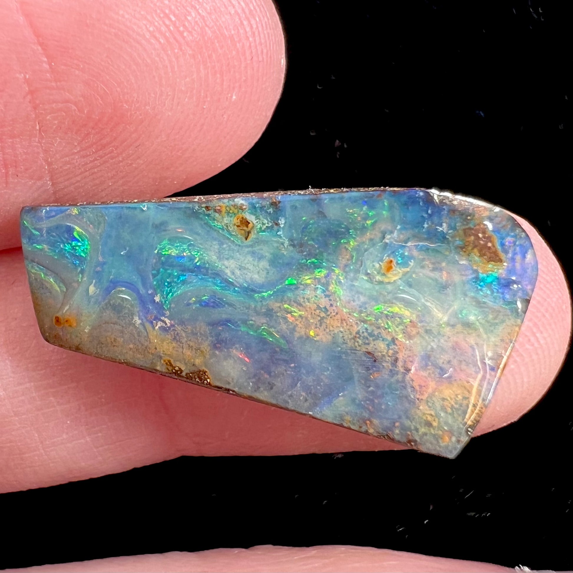 A loose, freeform cut boulder opal stone from Quilpie, Australia.