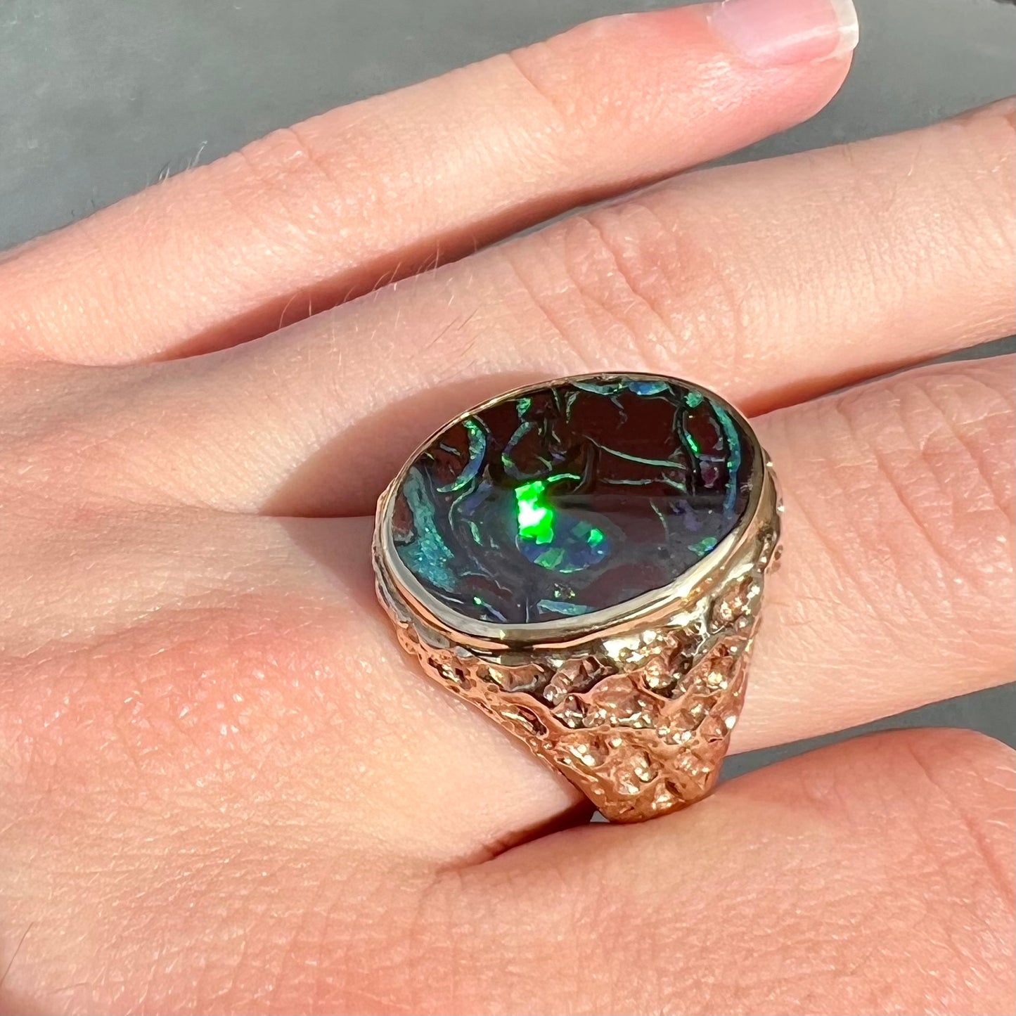 A men's yellow gold nugget style Koroit boulder opal solitaire ring.