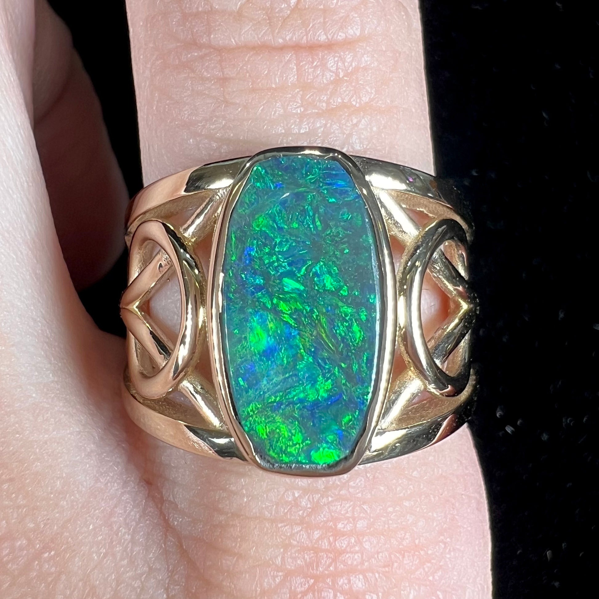 A men's natural Lightning Ridge, Australian black opal solitaire ring cast in yellow gold.