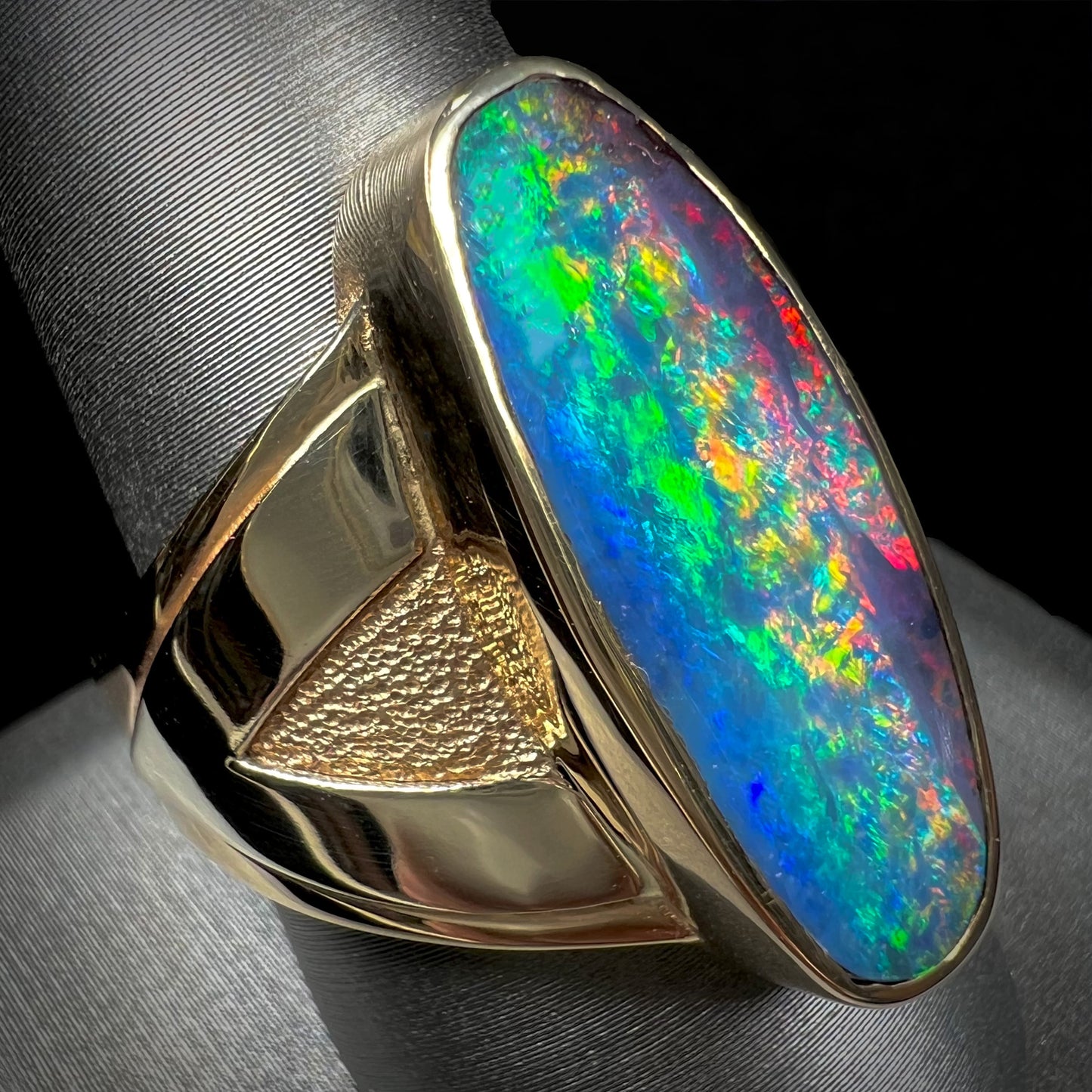 A men's two-tone gold solitaire ring set with a natural boulder opal from Koroit Mining District, Australia.