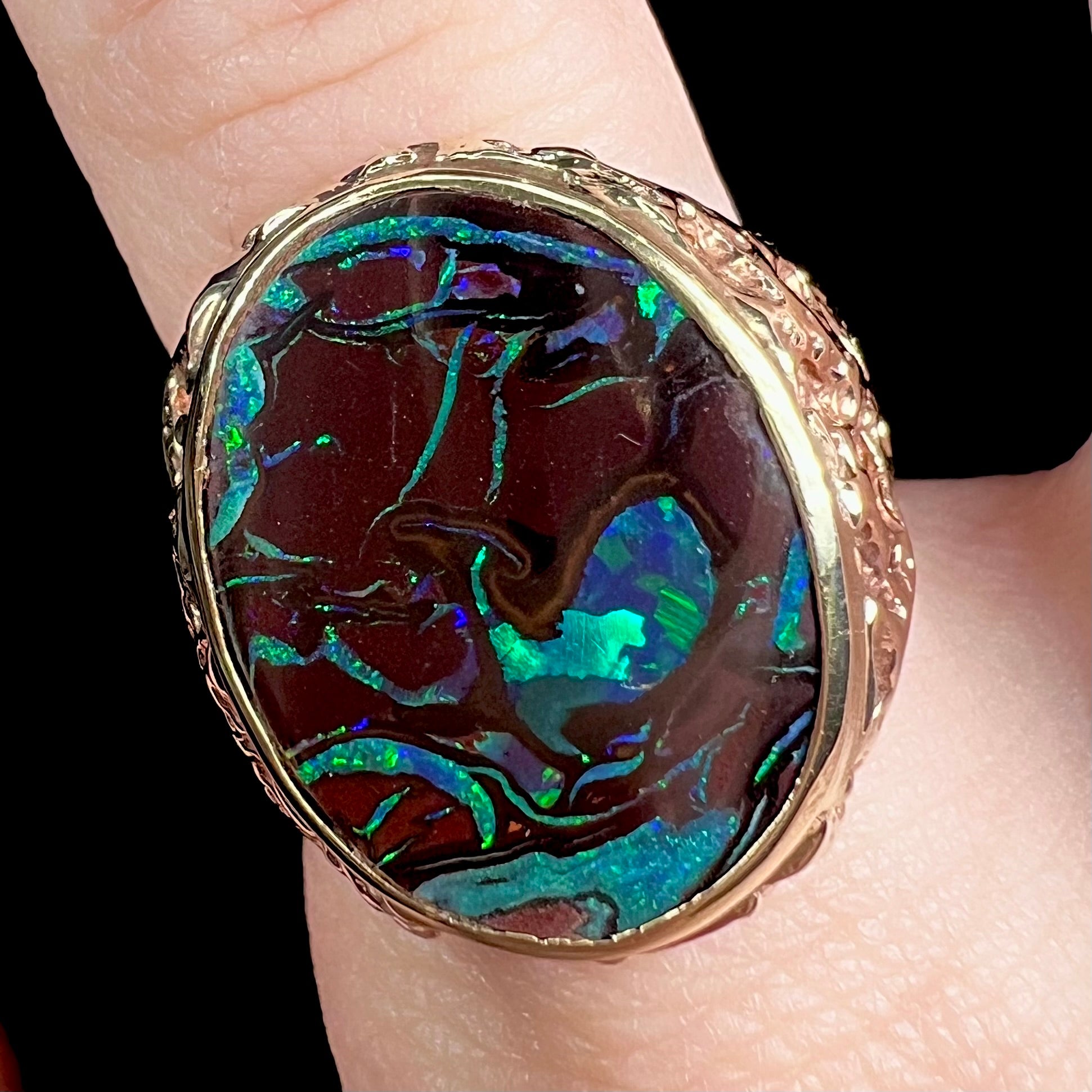 A men's yellow gold nugget style Koroit boulder opal solitaire ring.