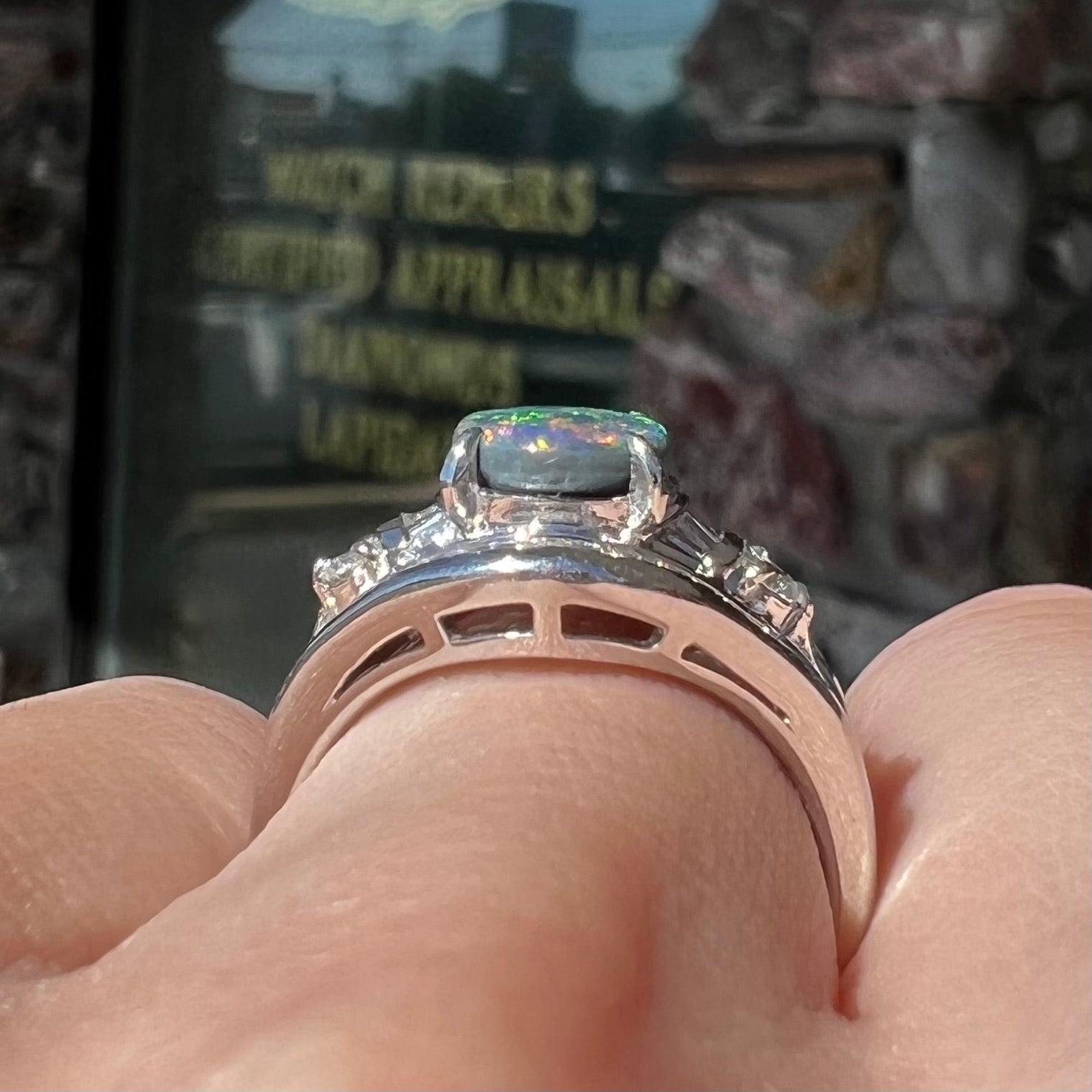 A platinum Lightning Ridge black opal ring set with baguette cut diamonds.  The opal is an oval cabochon cut.