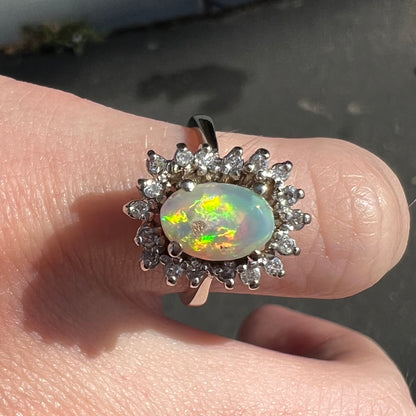 A white crystal opal ring cast in white gold with a halo of round cut diamonds.