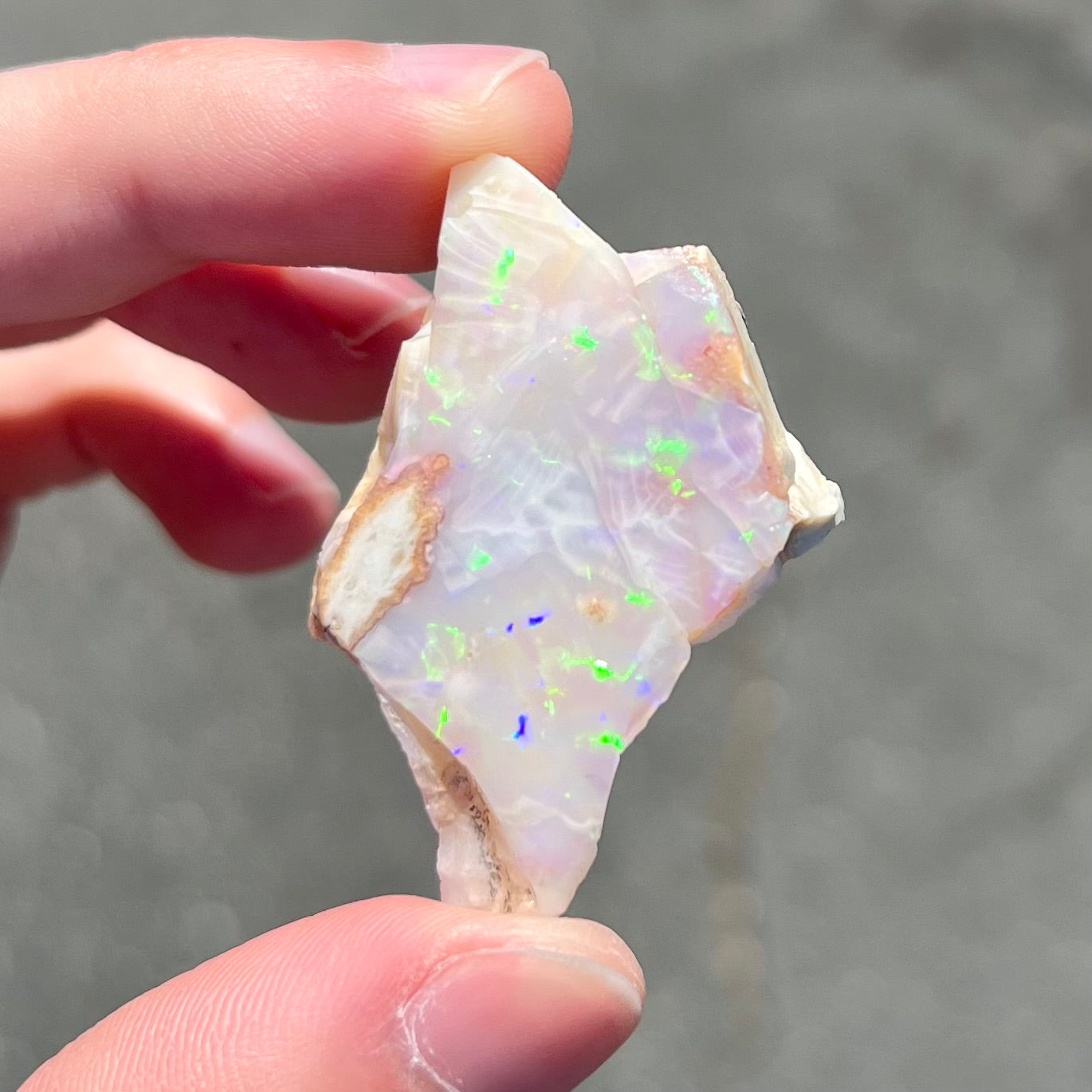 A loose, polished specimen of white crystal opal from Spencer, Idaho, USA.