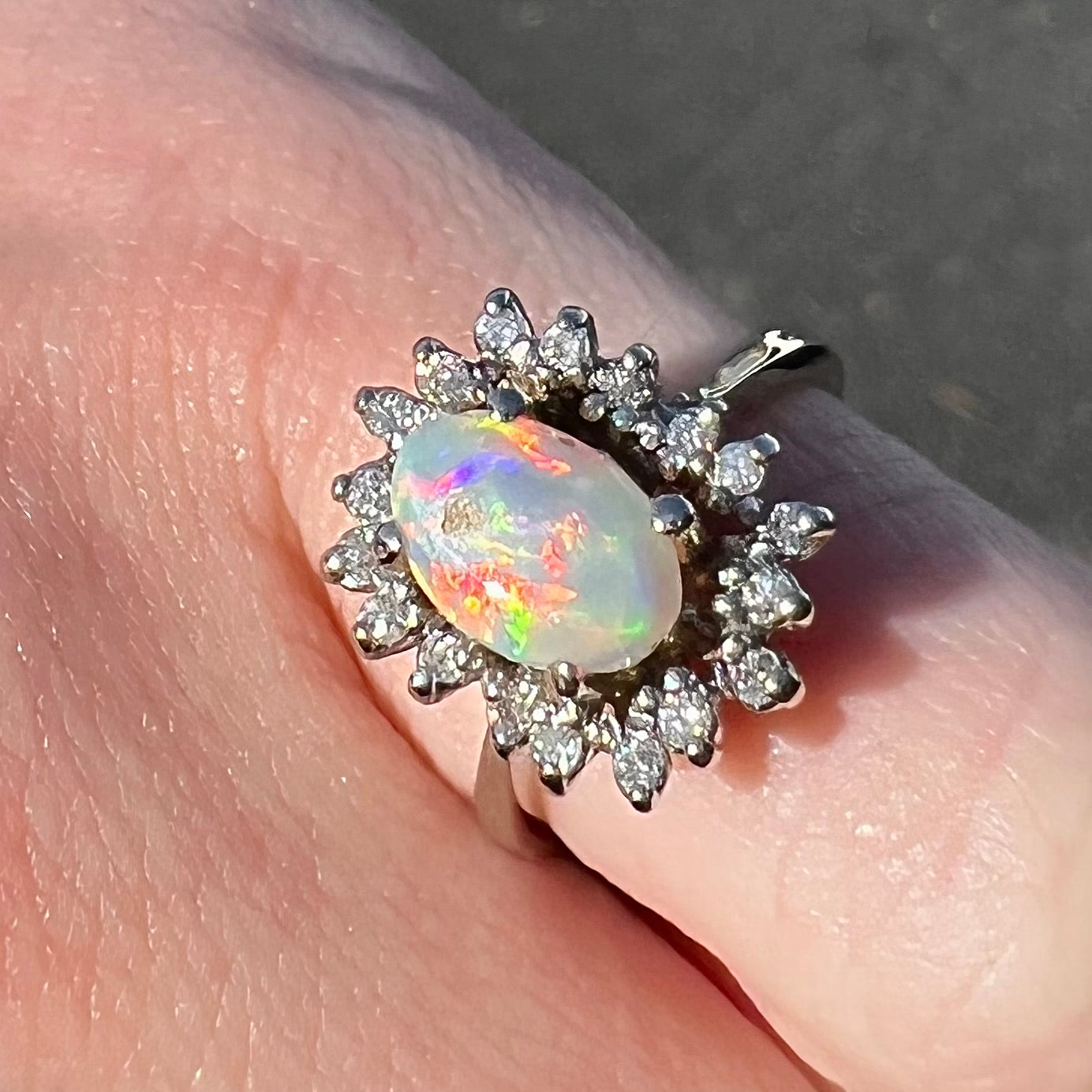 A white crystal opal ring cast in white gold with a halo of round cut diamonds.