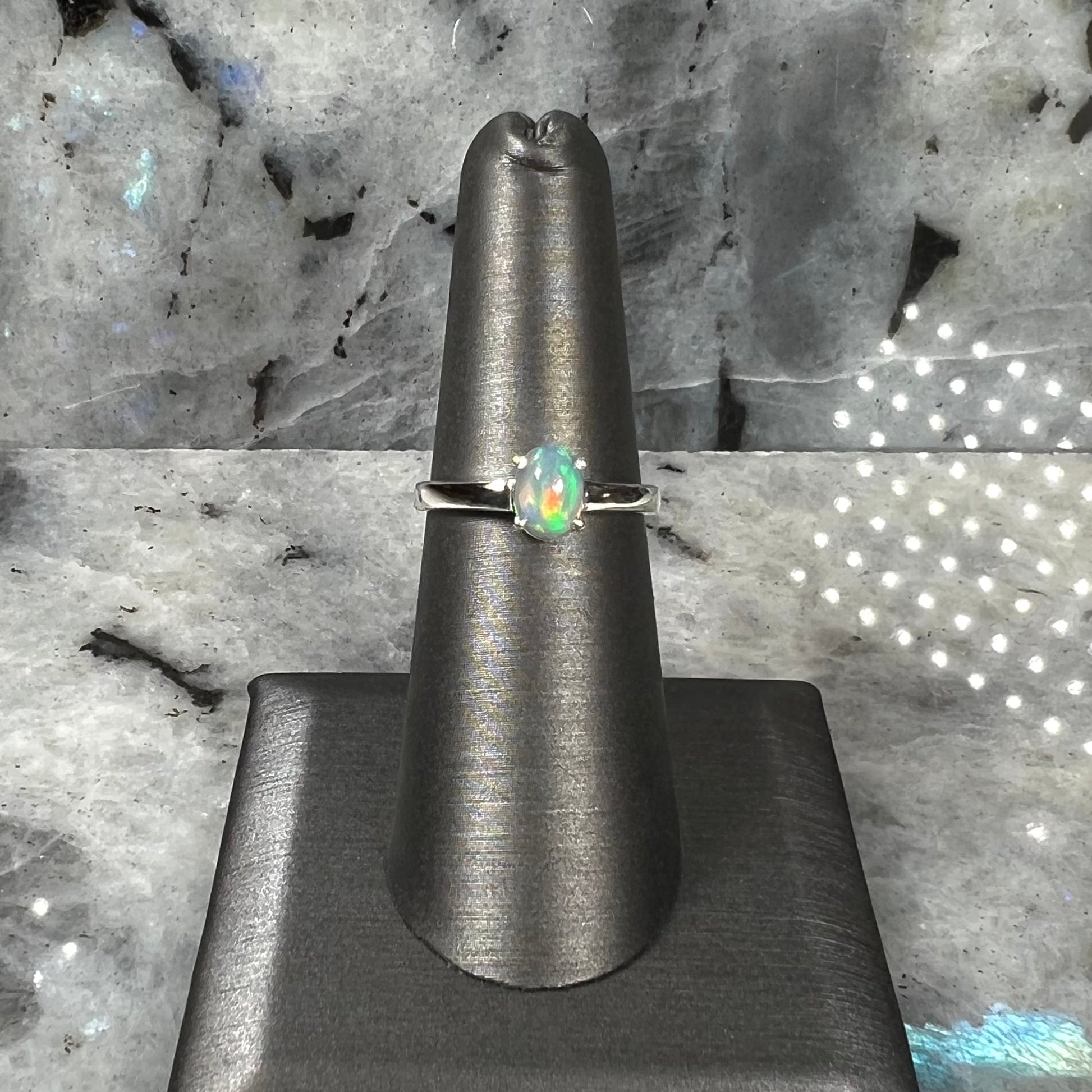 A silver, prong set, oval cabochon cut Ethiopian opal solitaire ring.
