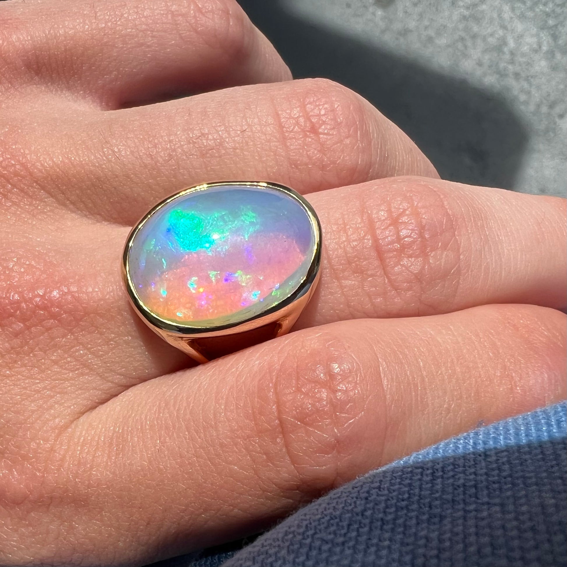 A gold split shank solitaire ring set with an oval cabochon cut 16.83 carat Ethiopian jelly fire opal.