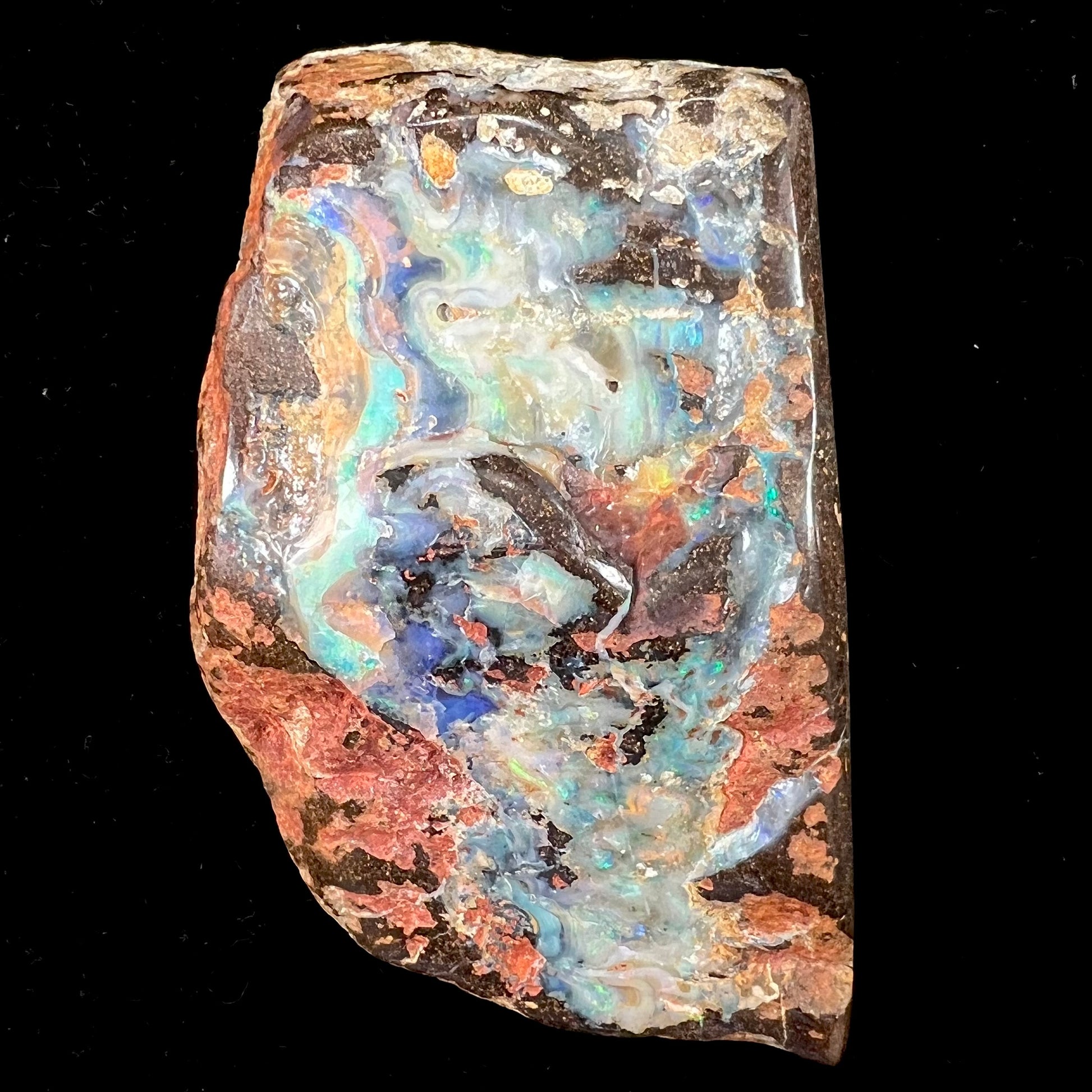 A hand-sized, polished Quilpie boulder opal specimen.  The stone shows blue, green, and orange flashes.