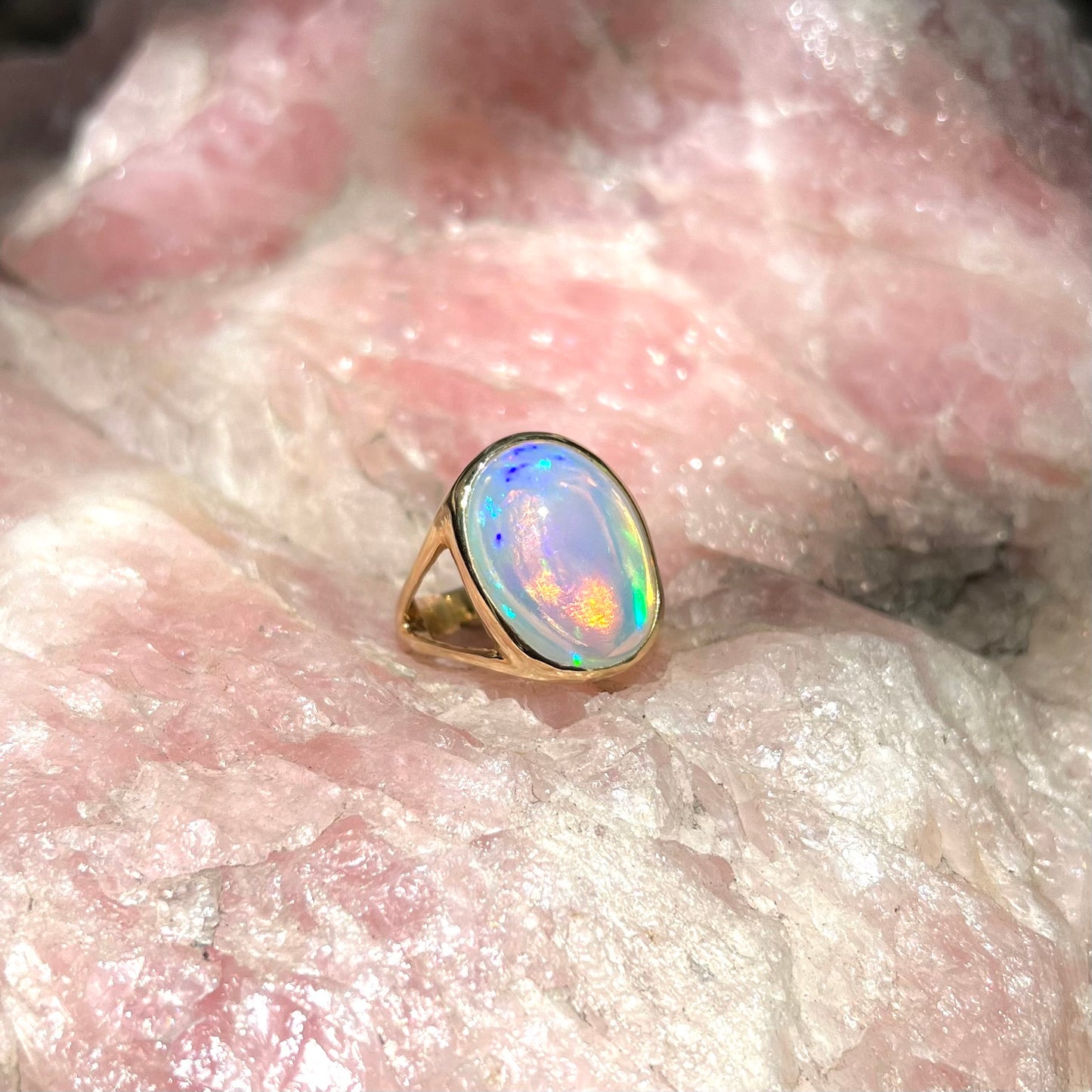 A gold split shank solitaire ring set with an oval cabochon cut 16.83 carat Ethiopian jelly fire opal.