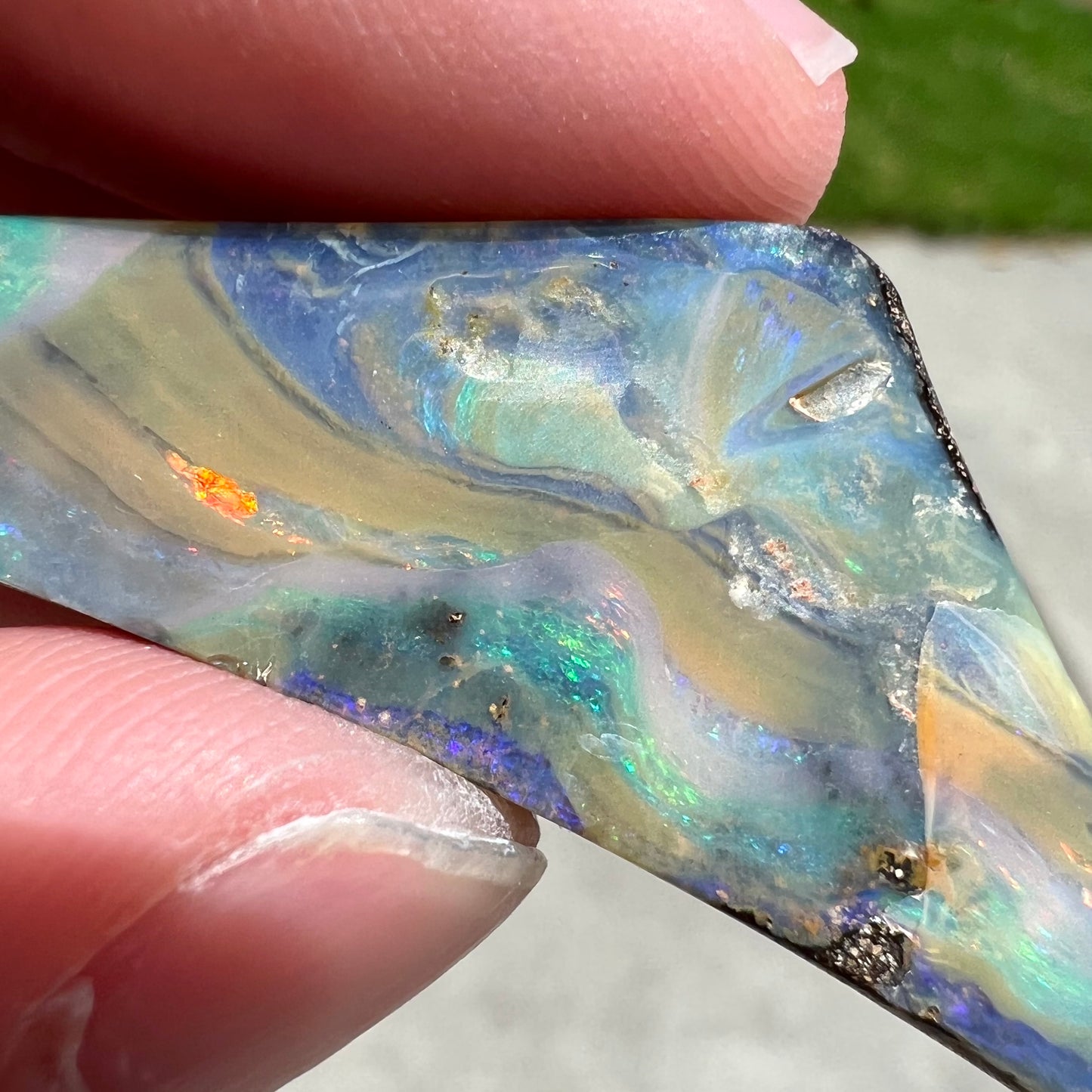 A loose, triangular shaped boulder opal stone from Queensland, Australia.
