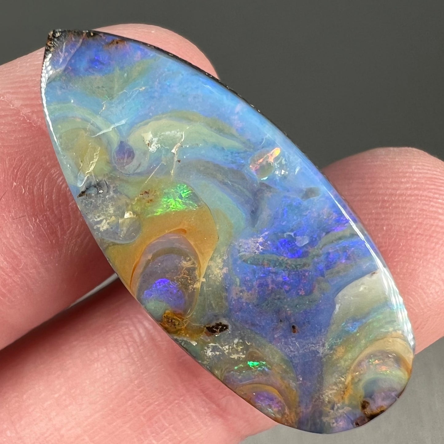 A loose, natural, pear shaped boulder opal stone from Quilpie, Australia.