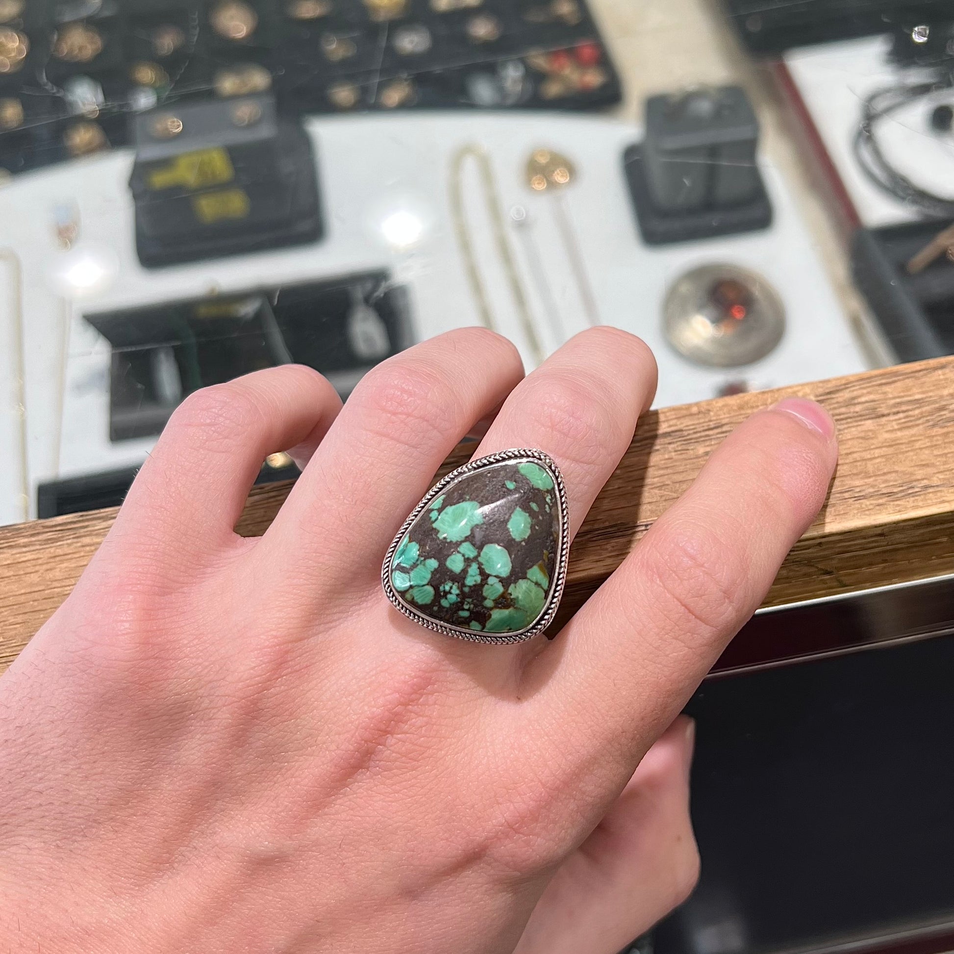 A sterling silver ring bezel set with a green spotted turquoise stone from Carico Lake, Nevada.