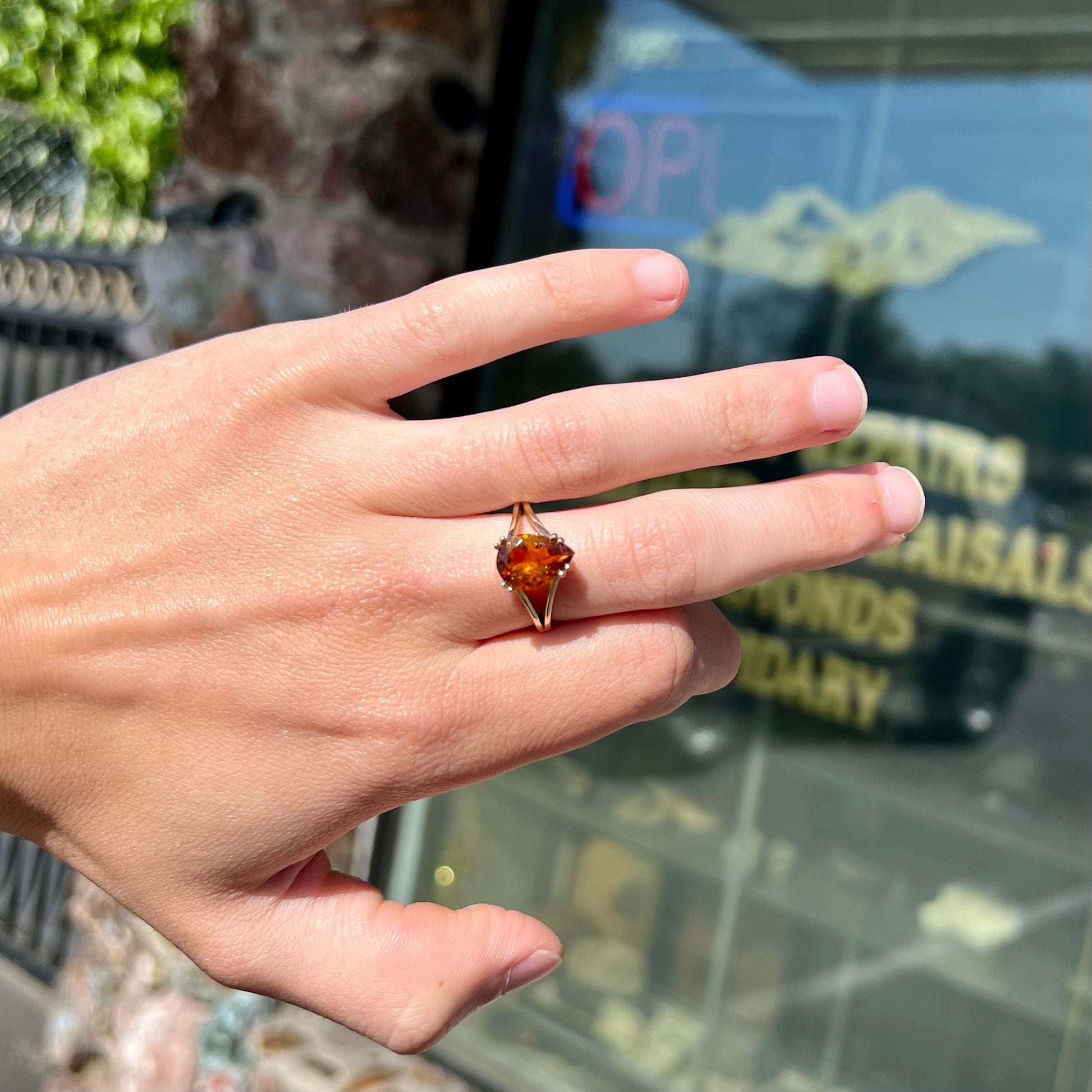 A gold split Euro shank solitaire ring set with an orange pear shape hessonite garnet stone.