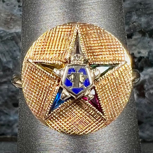 A gold ring set with multicolored synthetic sapphires forming a star with a blue enameled center, symbolizing the Order of the Eastern Star.