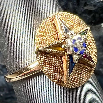 A gold ring set with multicolored synthetic sapphires forming a star with a blue enameled center, symbolizing the Order of the Eastern Star.