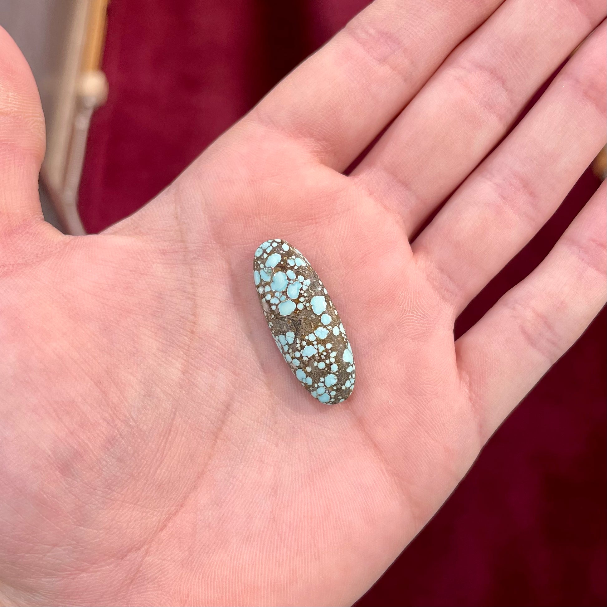 A loose, oval cabochon cut turquoise stone from the Number 8 Mine in Lander County, Nevada.