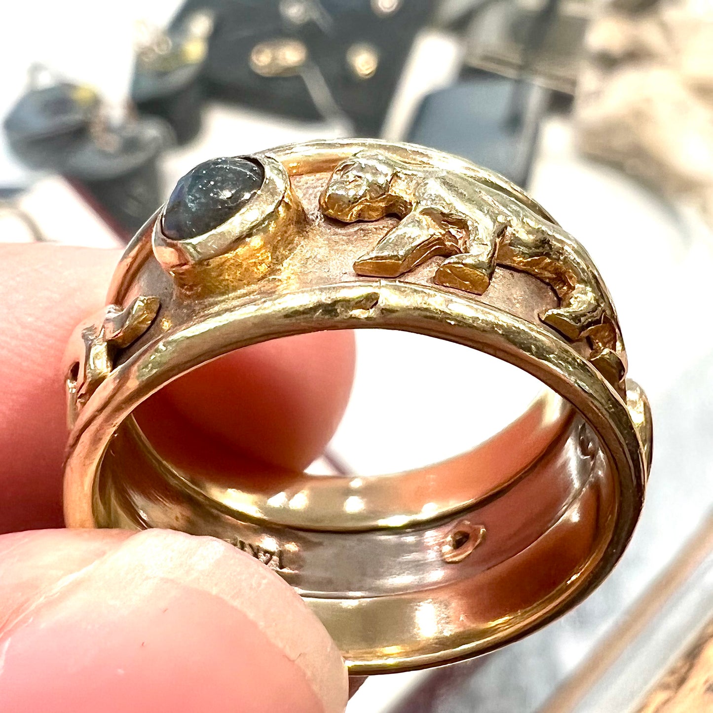 Men's gold ring set with three cabochon cut cat's eye alexandrite stones and panther designs.