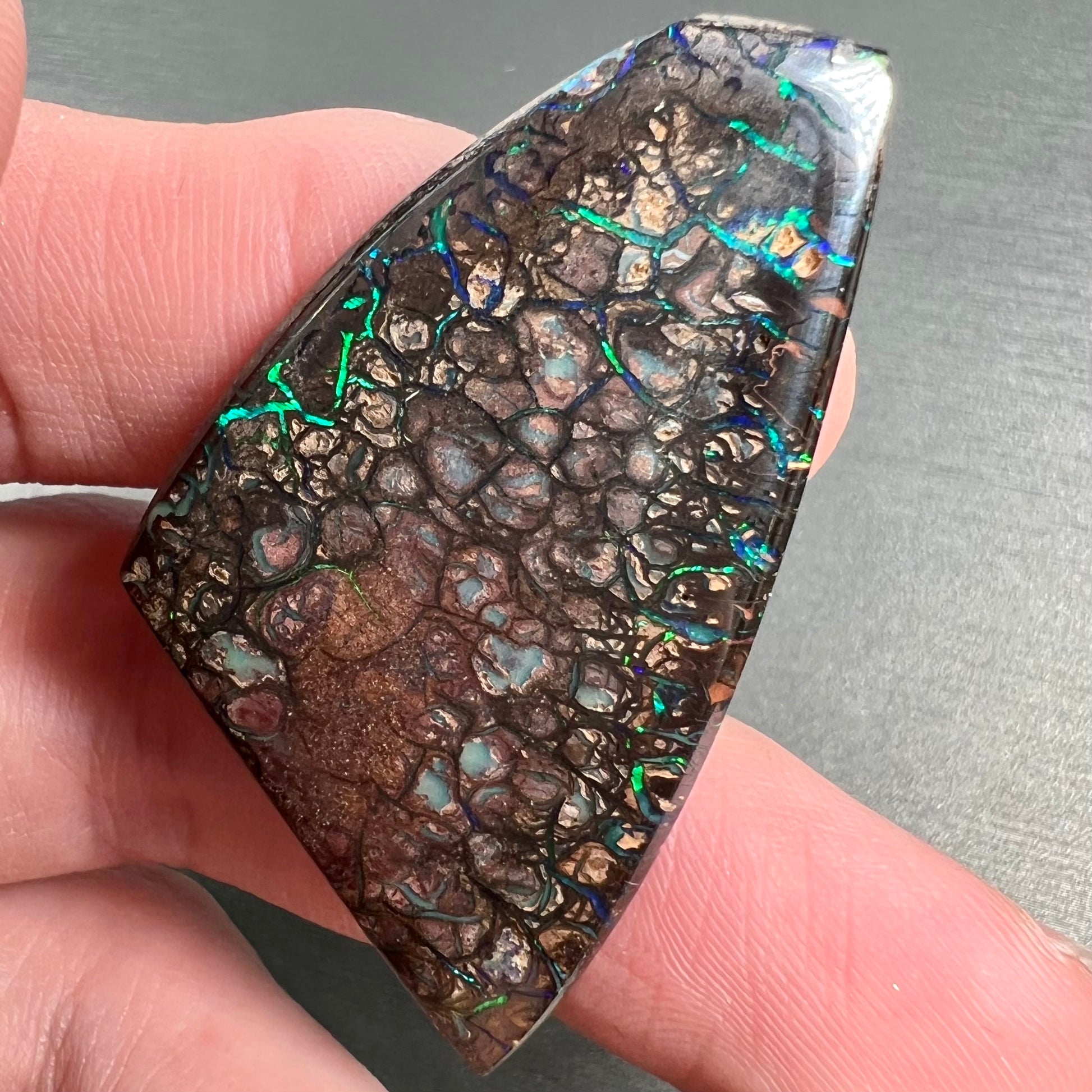 A loose, freeform cut polished Koroit boulder opal stone from Koroit Mining District, Australia.