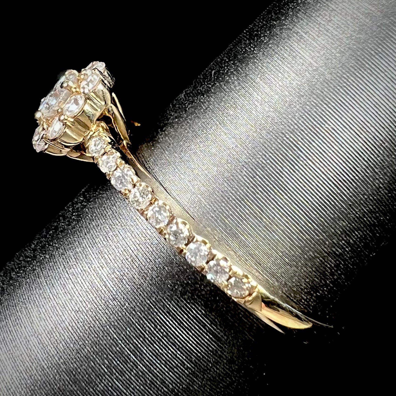 A ladies' diamond halo engagement ring cast in yellow gold.  The center stone is a 0.19ct round cut natural diamond.