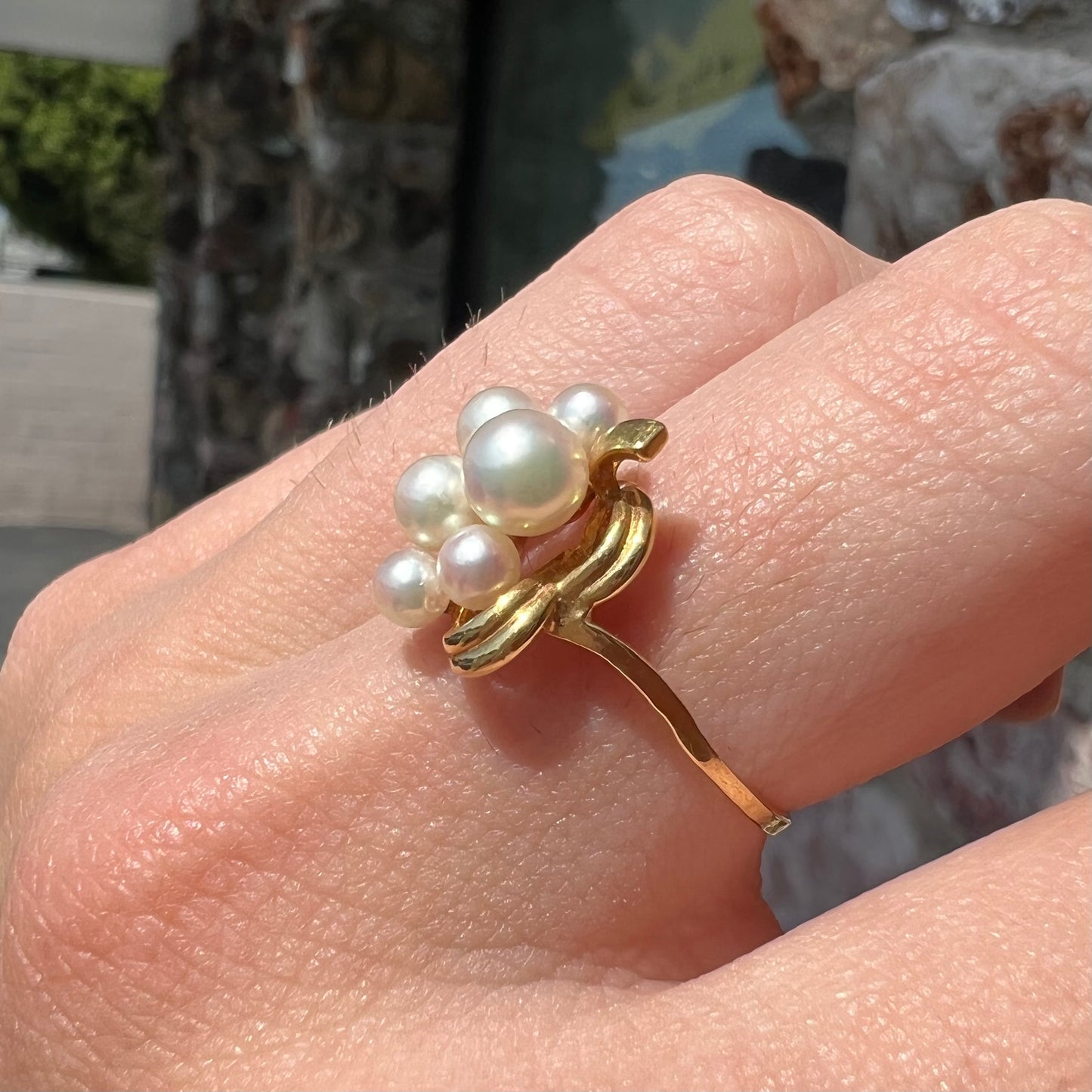 A yellow gold Akoya pearl cluster ring.  The pearls are round with pink overtones and resemble bubbles.