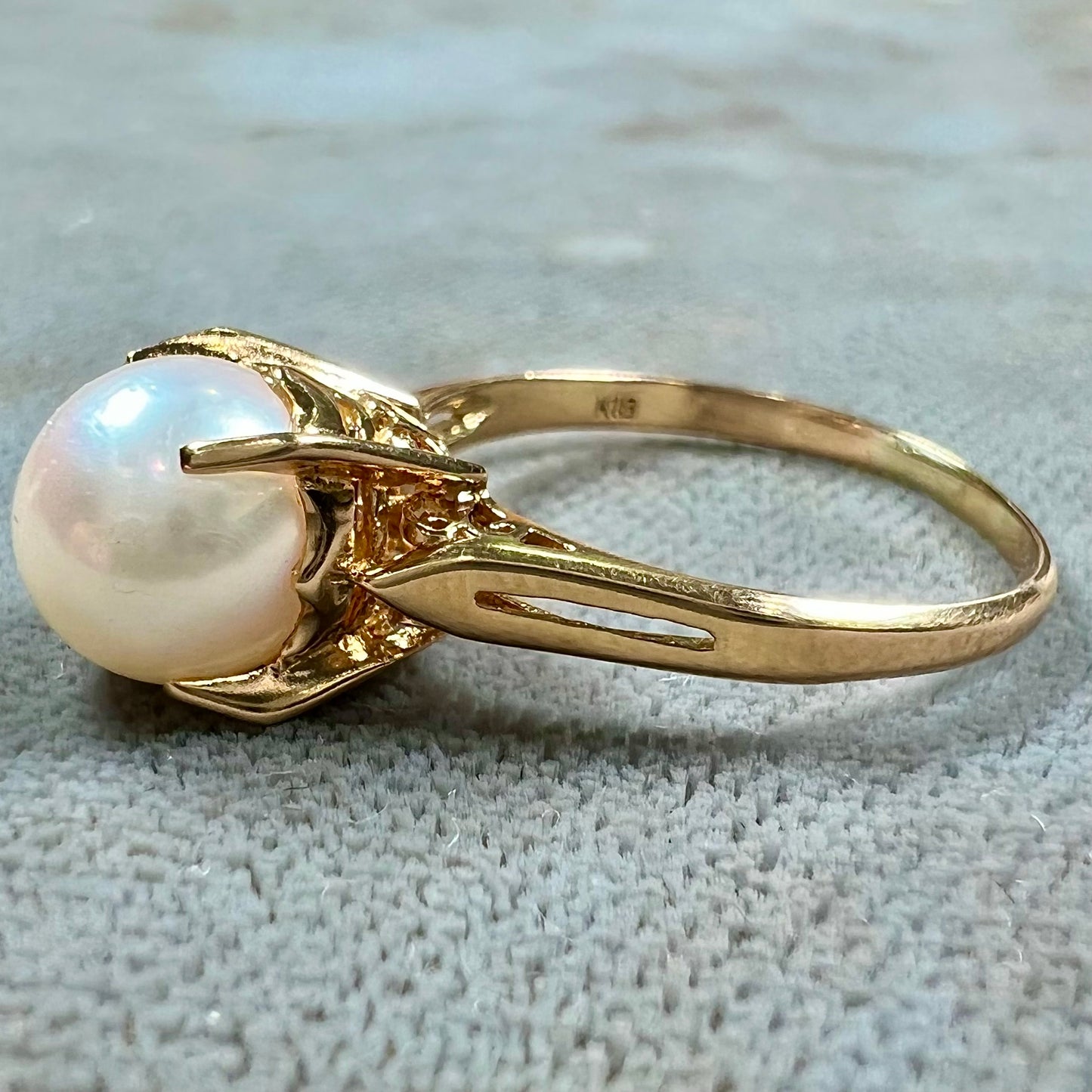 Round white pearl with pink overtones set in a vintage 18k yellow gold ring.