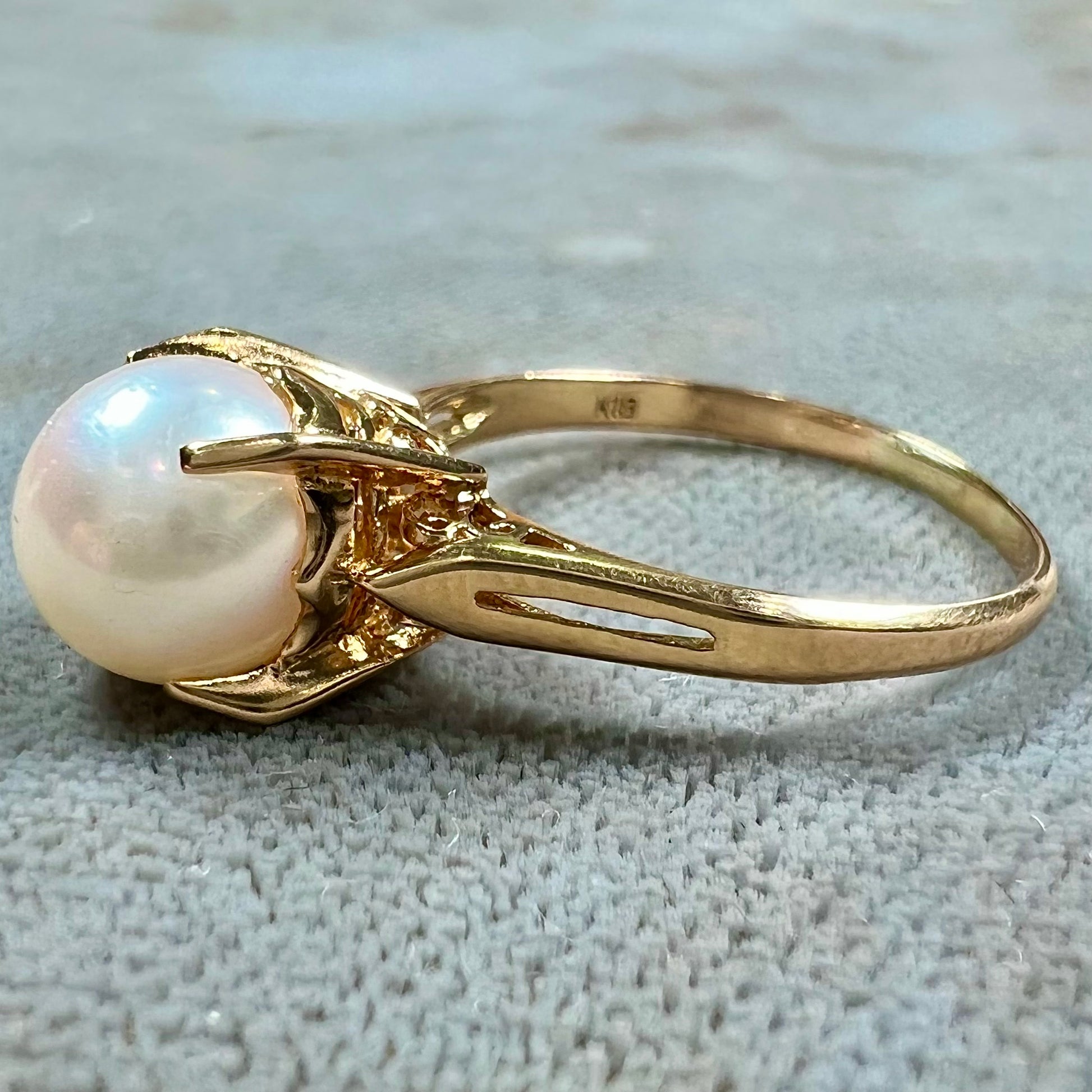 Round white pearl with pink overtones set in a vintage 18k yellow gold ring.