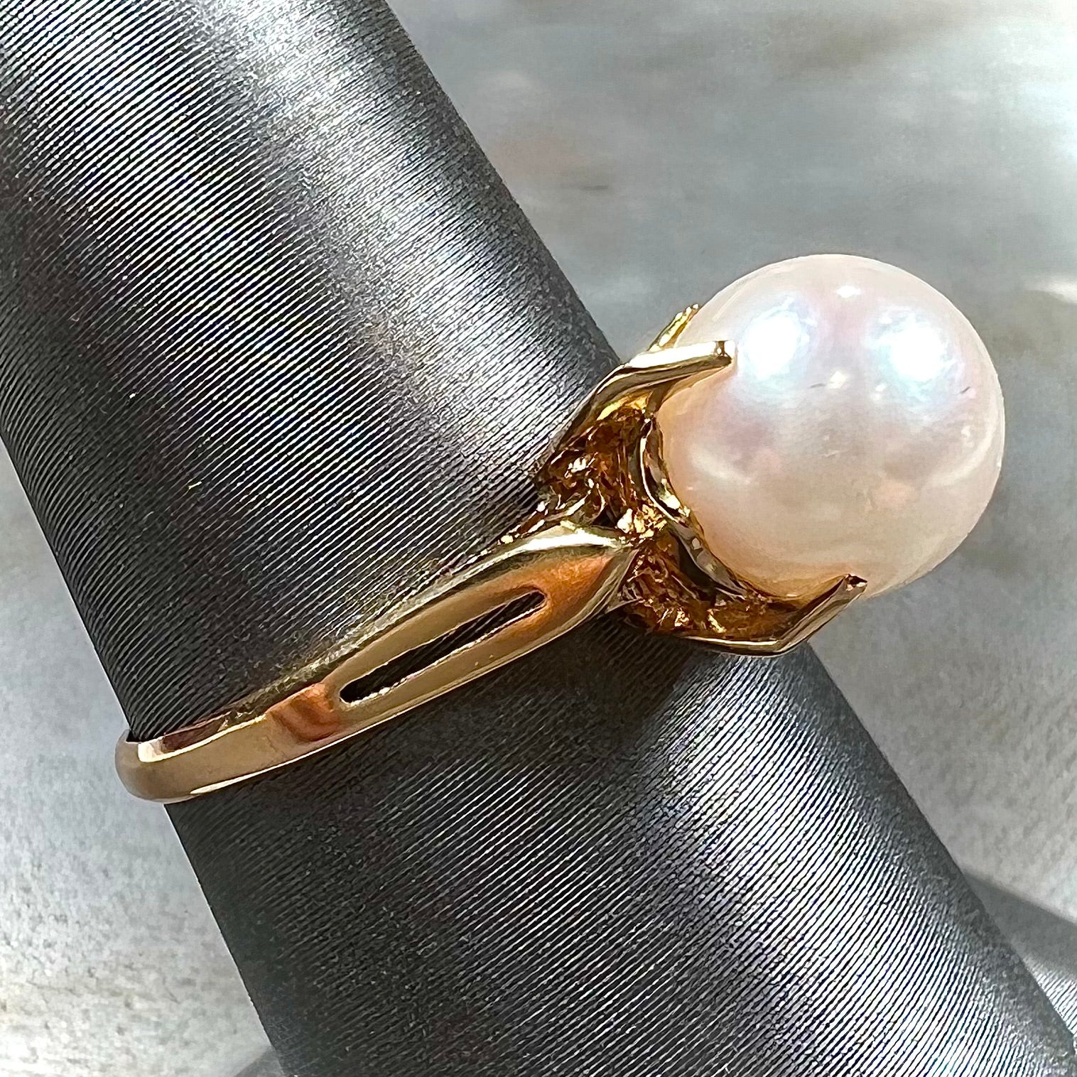 Round white pearl with pink overtones set in a vintage 18k yellow gold ring.