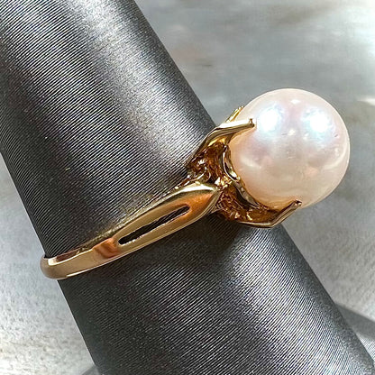Round white pearl with pink overtones set in a vintage 18k yellow gold ring.