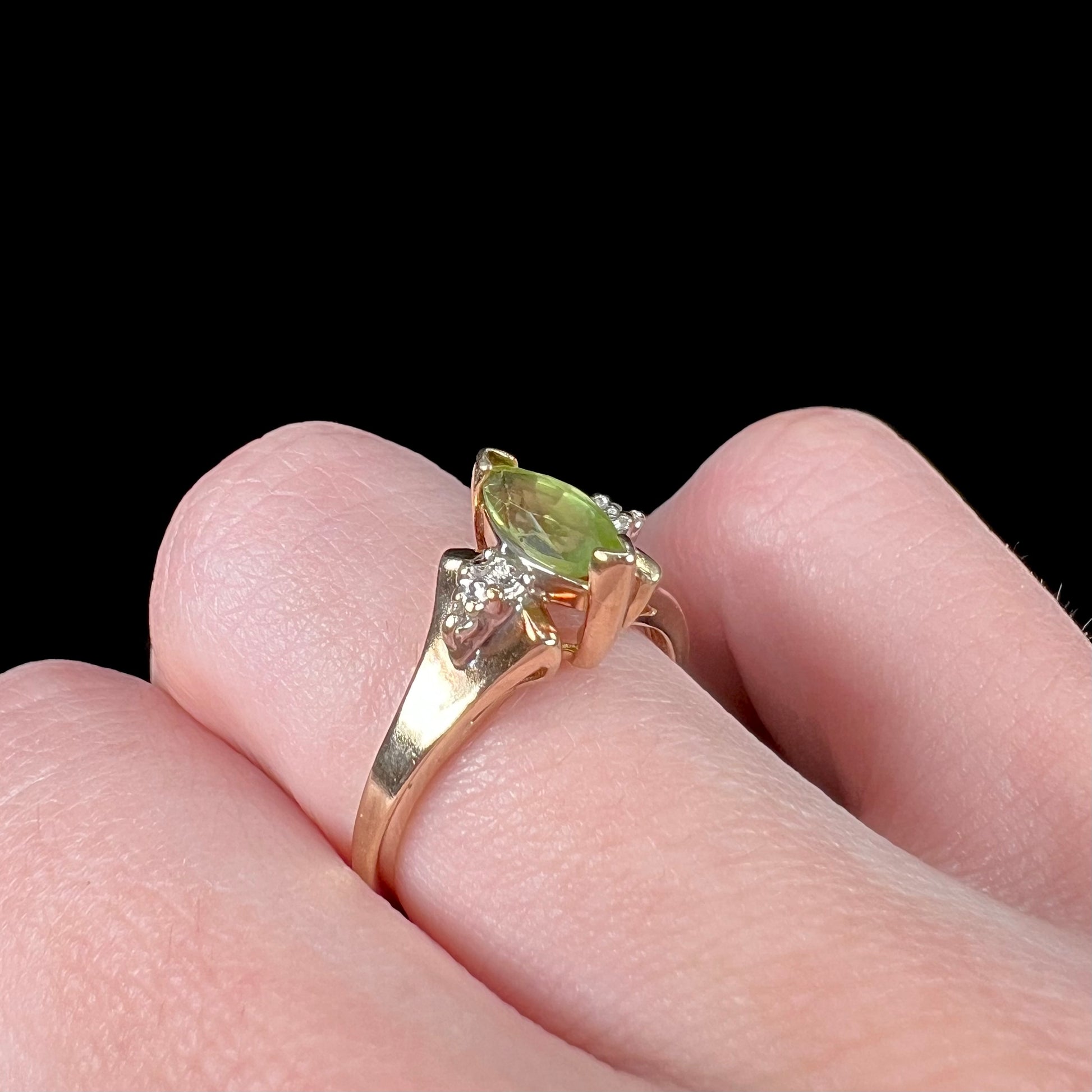 A ladies' marquise cut peridot and diamond ring in 10 karat yellow gold.