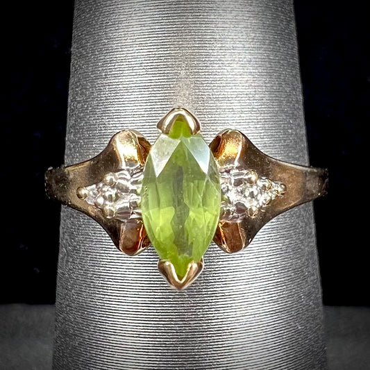 A ladies' marquise cut peridot and diamond ring in 10 karat yellow gold.