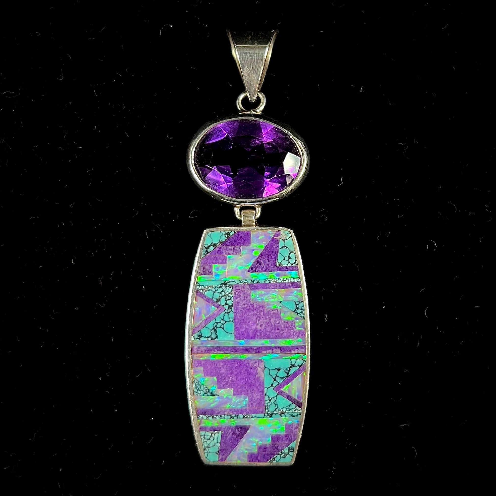 A sterling silver stone inlay necklace set with amethyst, sugilite, spiderweb turquoise, and lab created opal by Navajo artist, Peterson Chee.