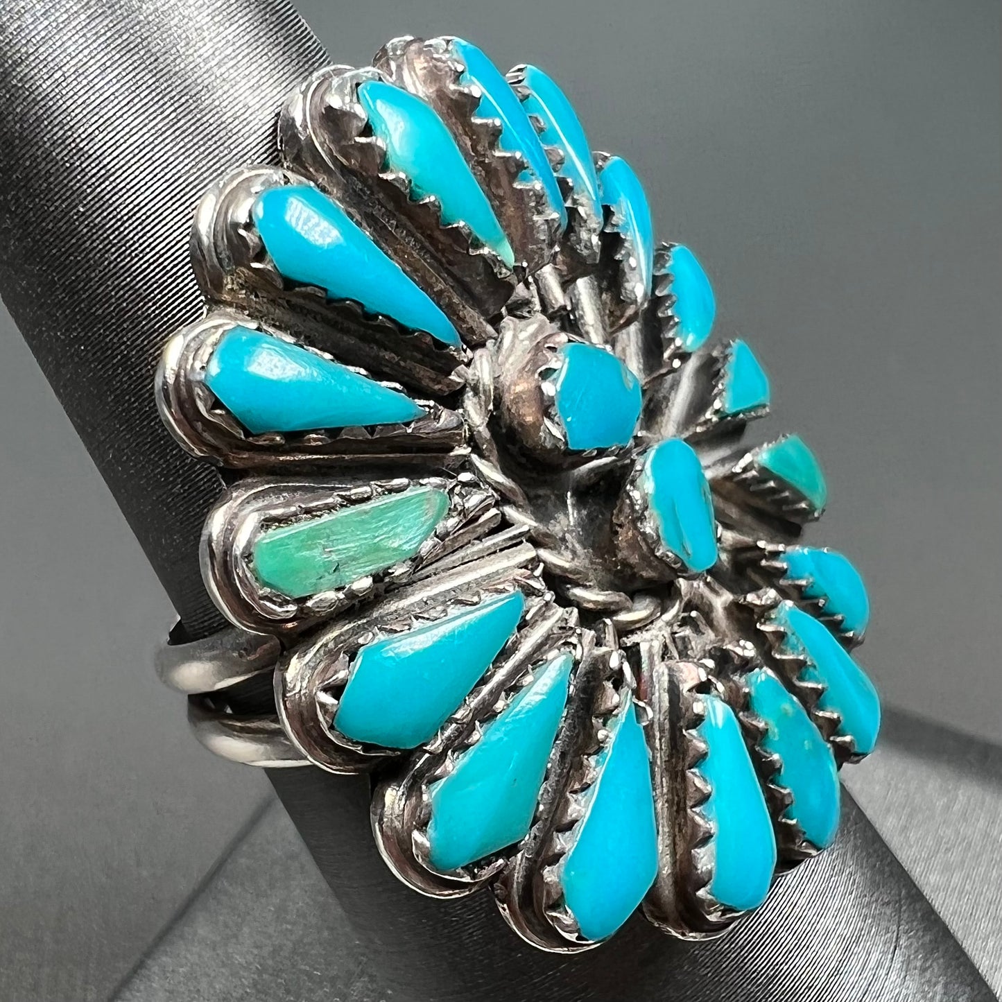 A handmade, sterling silver Zuni Indian ring petit point set with turquoise stones.  The ring has a split shank.