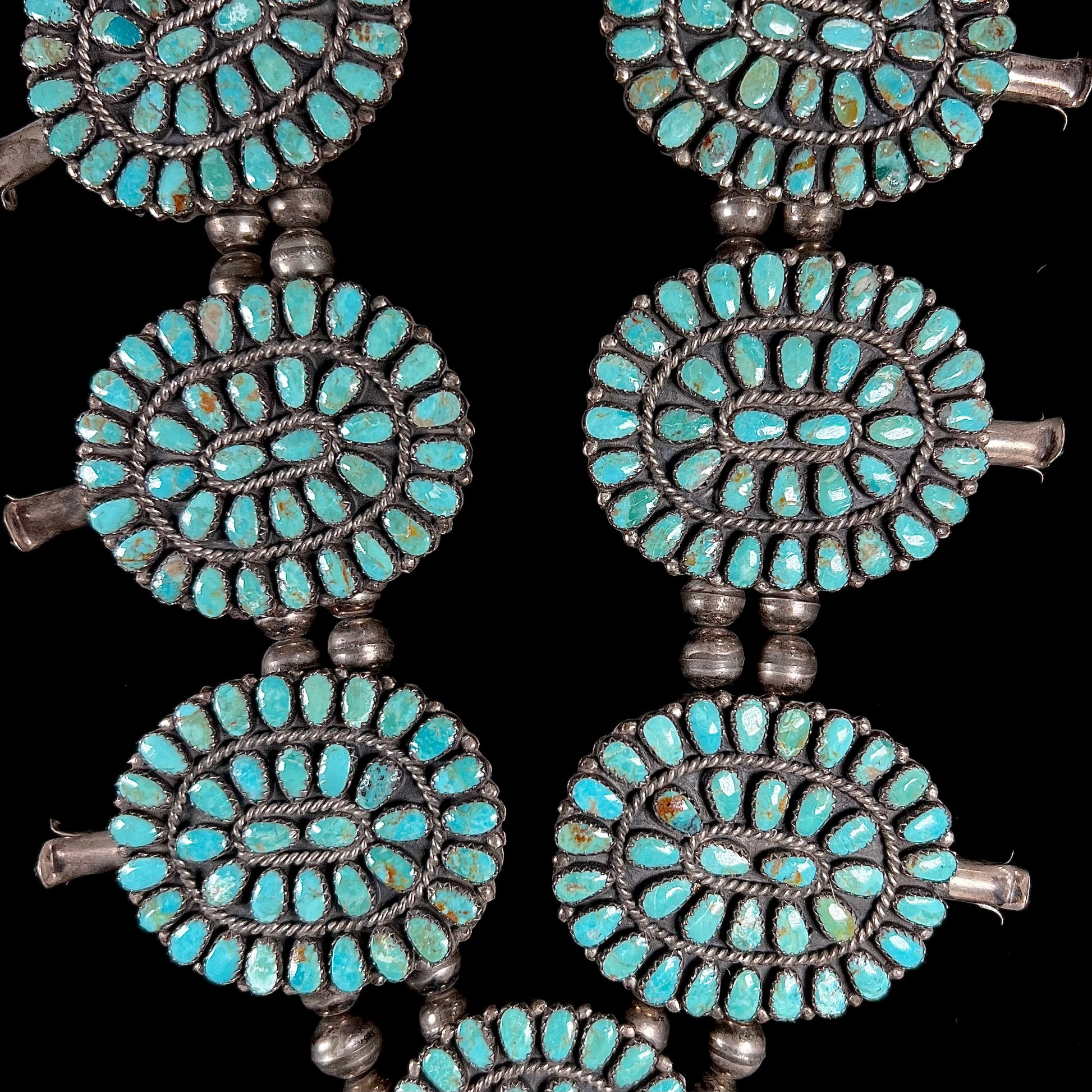 A Native American silver squash blossom turquoise petit point set with turquoise by Larry Moses Begay.