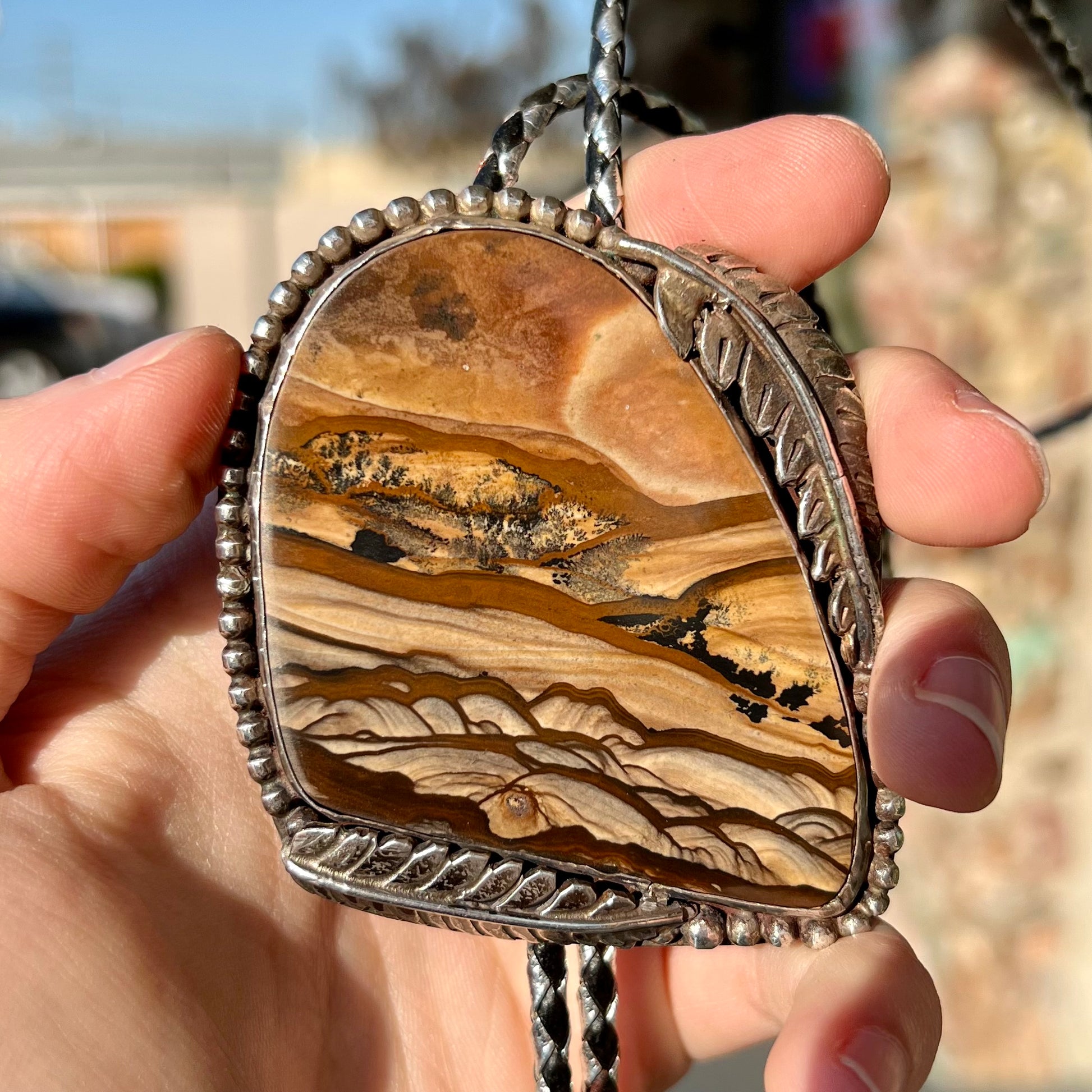 A men's sterling silver bolo tie set with a Biggs picture jasper stone.